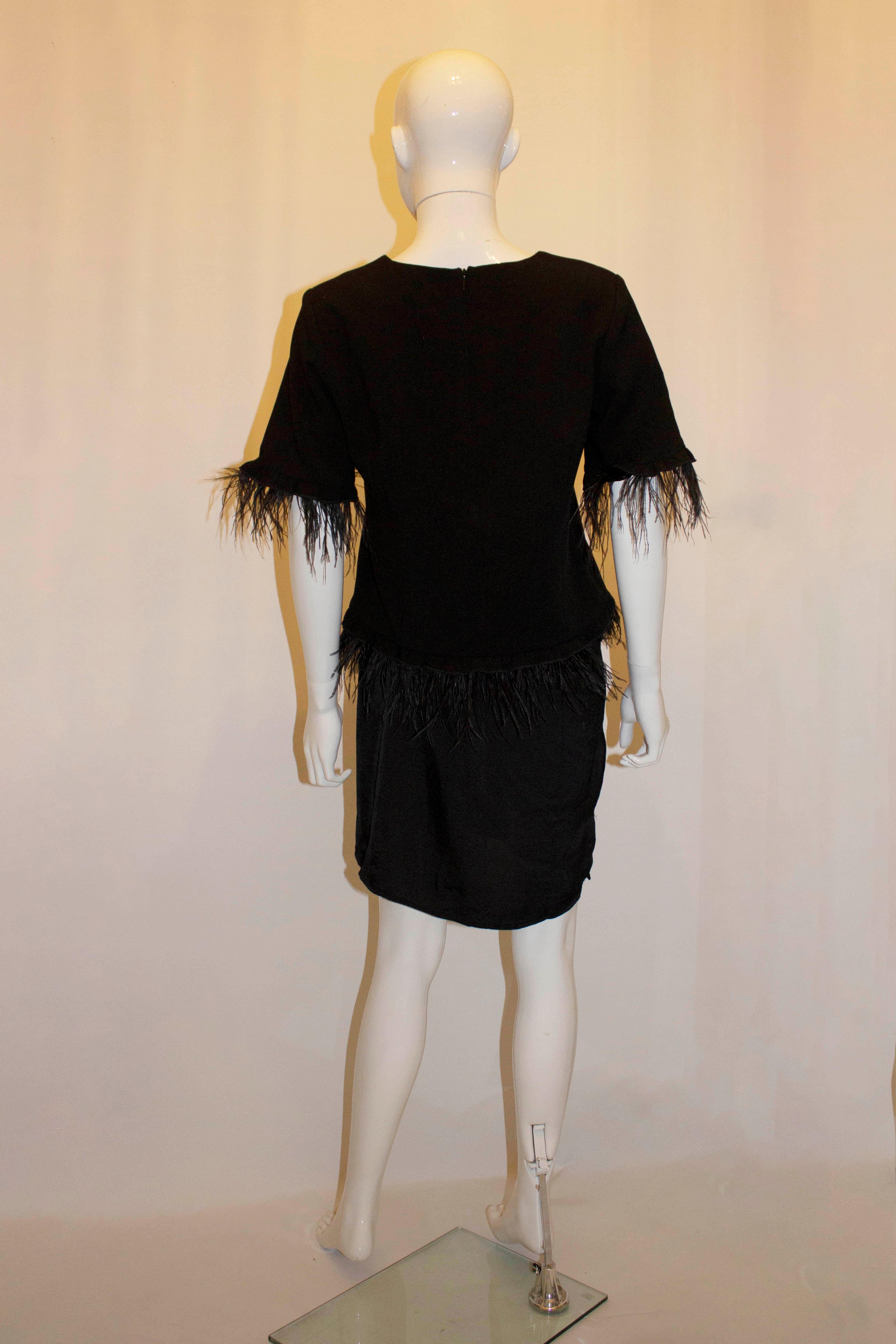 A fun black evening top with feather detail by Spell. The top has a back zip opening, elbow length sleaves , and is lined. Measurements  Size UK10 Bust up to 38'', length including feathers 24''