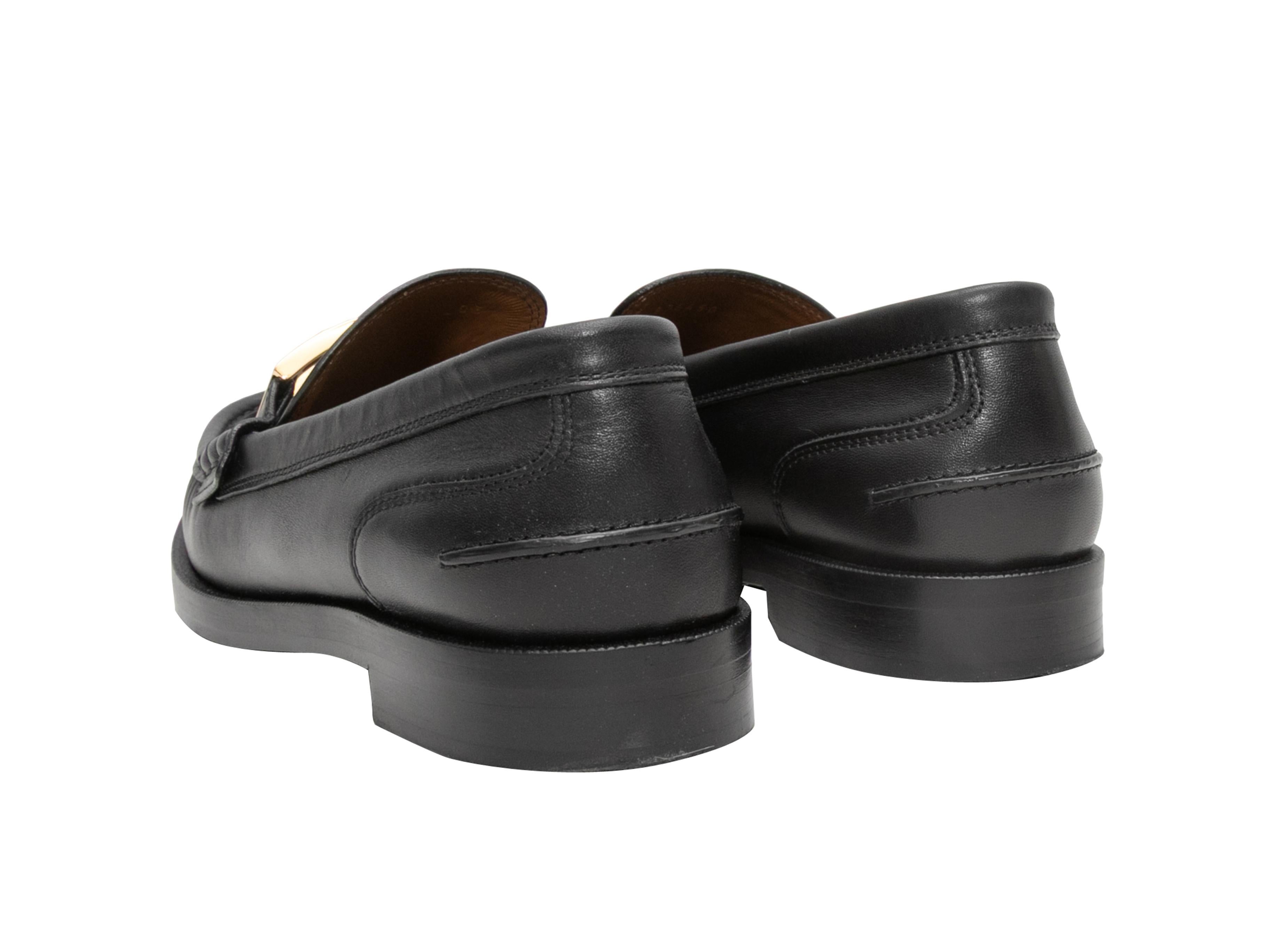 Black leather loafers by Fendi. Gold-tone logo hardware at tops. Stacked heels. 1