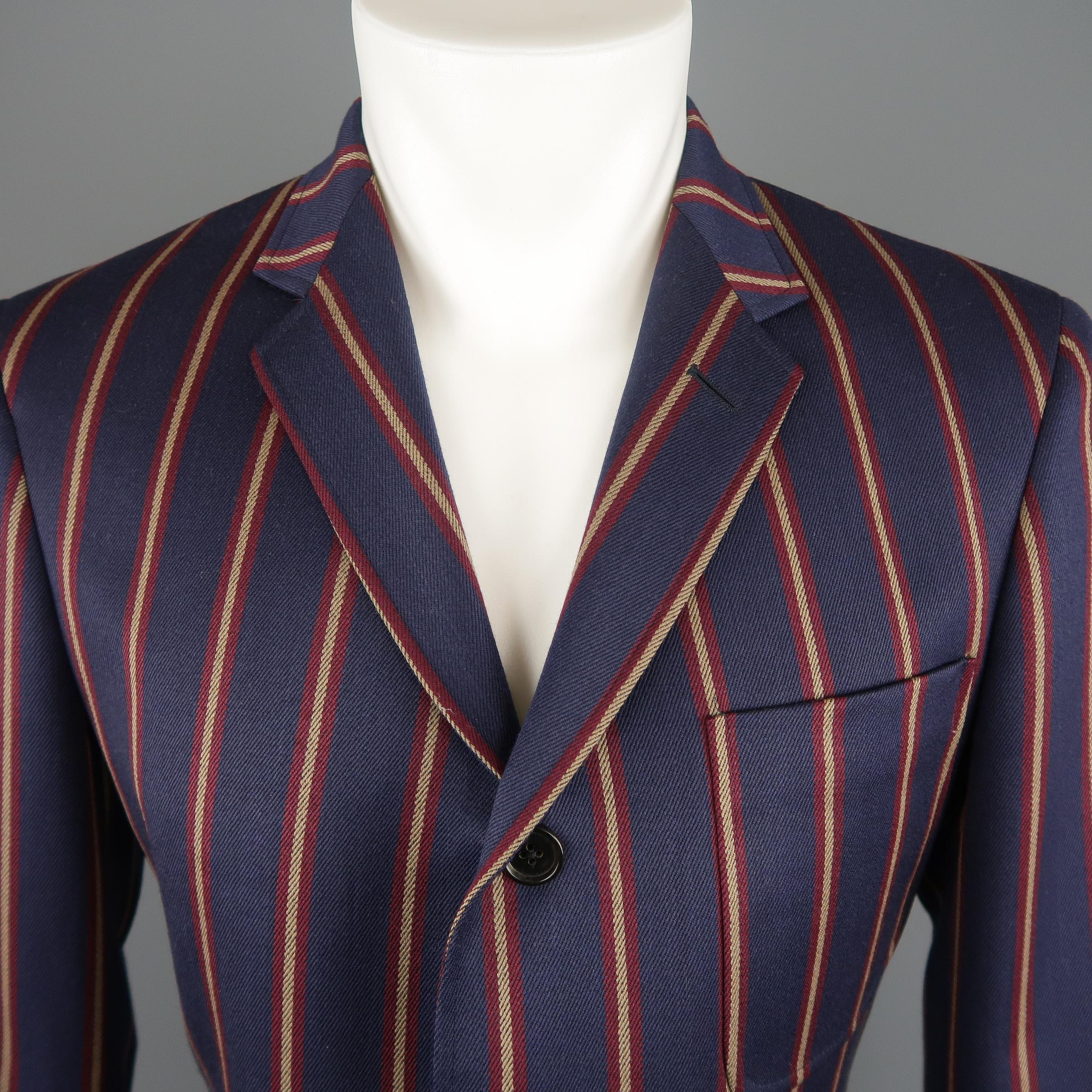 BLACK FLEECE by THOM BROWNE sport coat comes in navy wool with gold and burgundy stripe pattern,  notch lapel, single breasted, three button front, and patch pockets. Made in USA. Retail price $1,800.00. 
 
Excellent Pre-Owned Condition.
Marked: