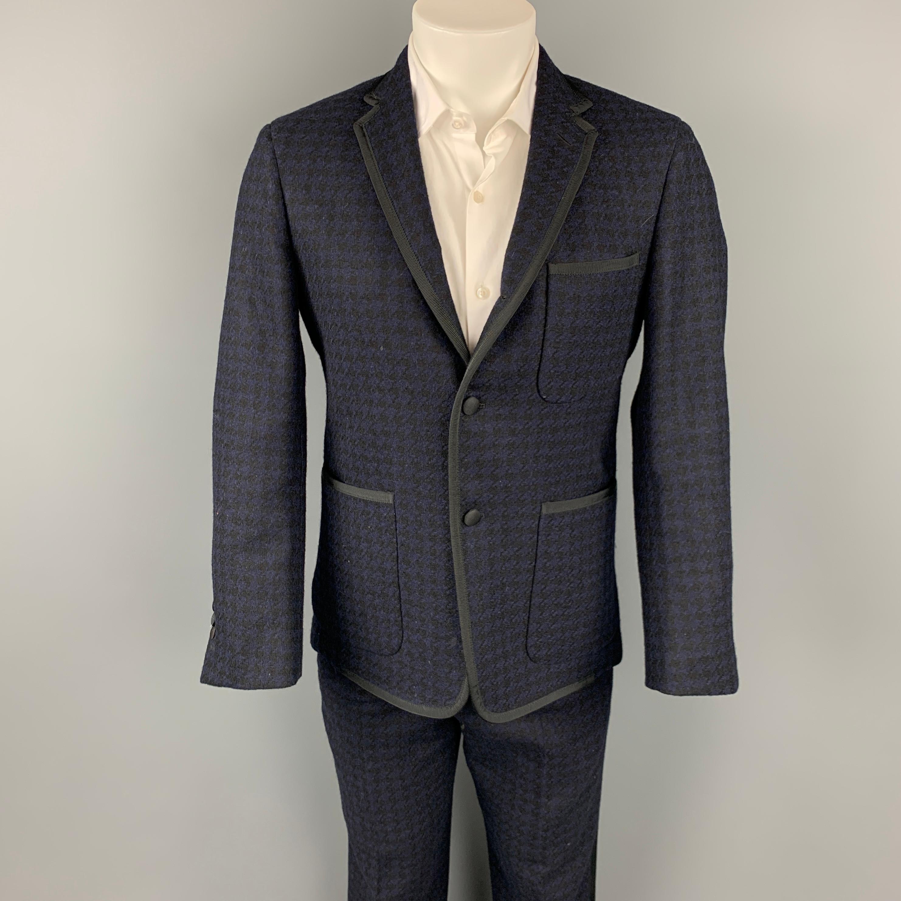 BLACK FLEECE tuxedo suit comes in a black & navy houndstooth wool with a grosgrain trim and includes a single breasted, three button sport coat with a notch lapel and matching flat front trousers. Made in USA.

Very Good Pre-Owned Condition.
Marked: