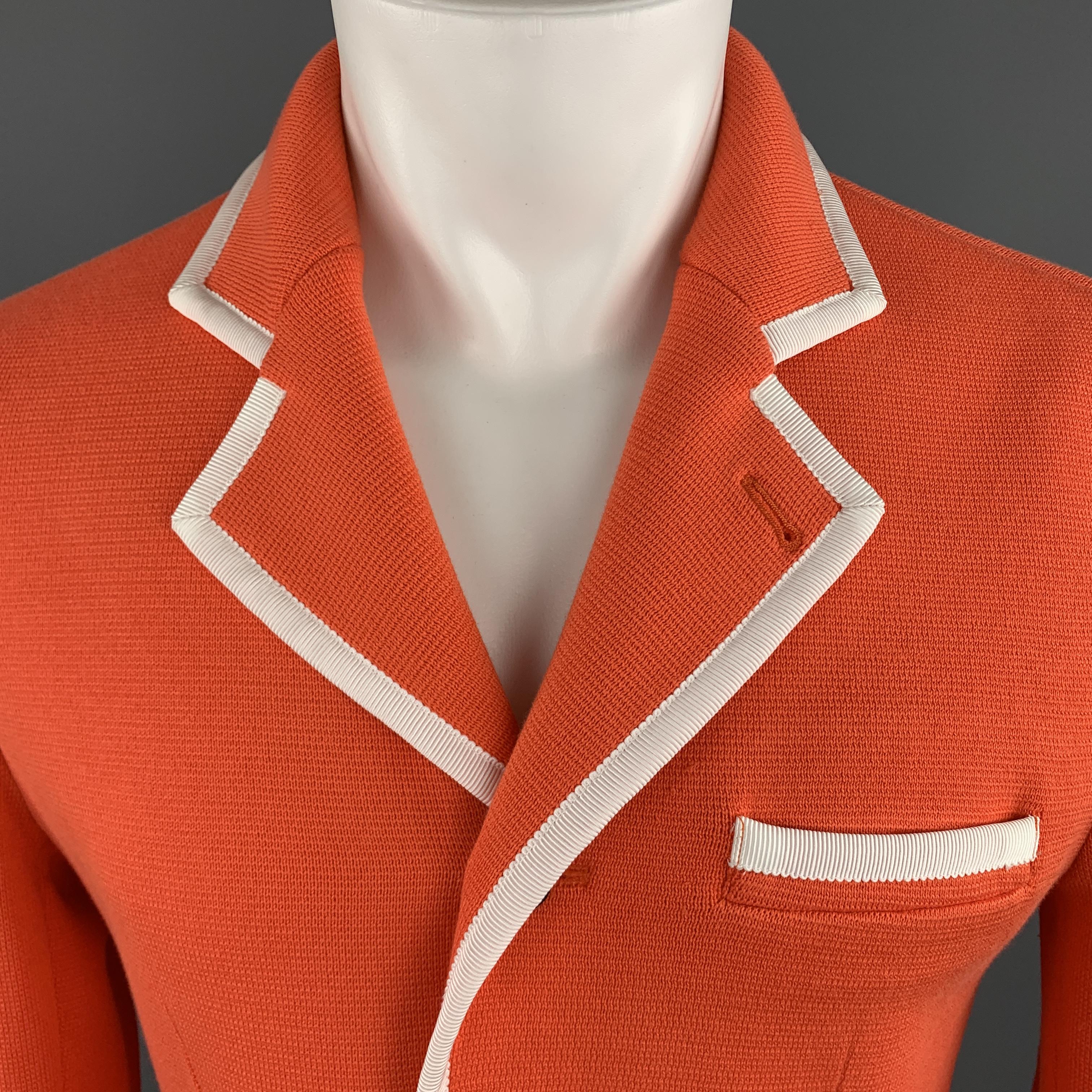 BLACK FLEECE sport coat comes in orange cotton knit with a notch lapel, single breasted, two silver tone metal button front, and cream faille contrast piping throughout. Tags removed. As is.

Excellent Pre-Owned Condition.
Marked: (no size