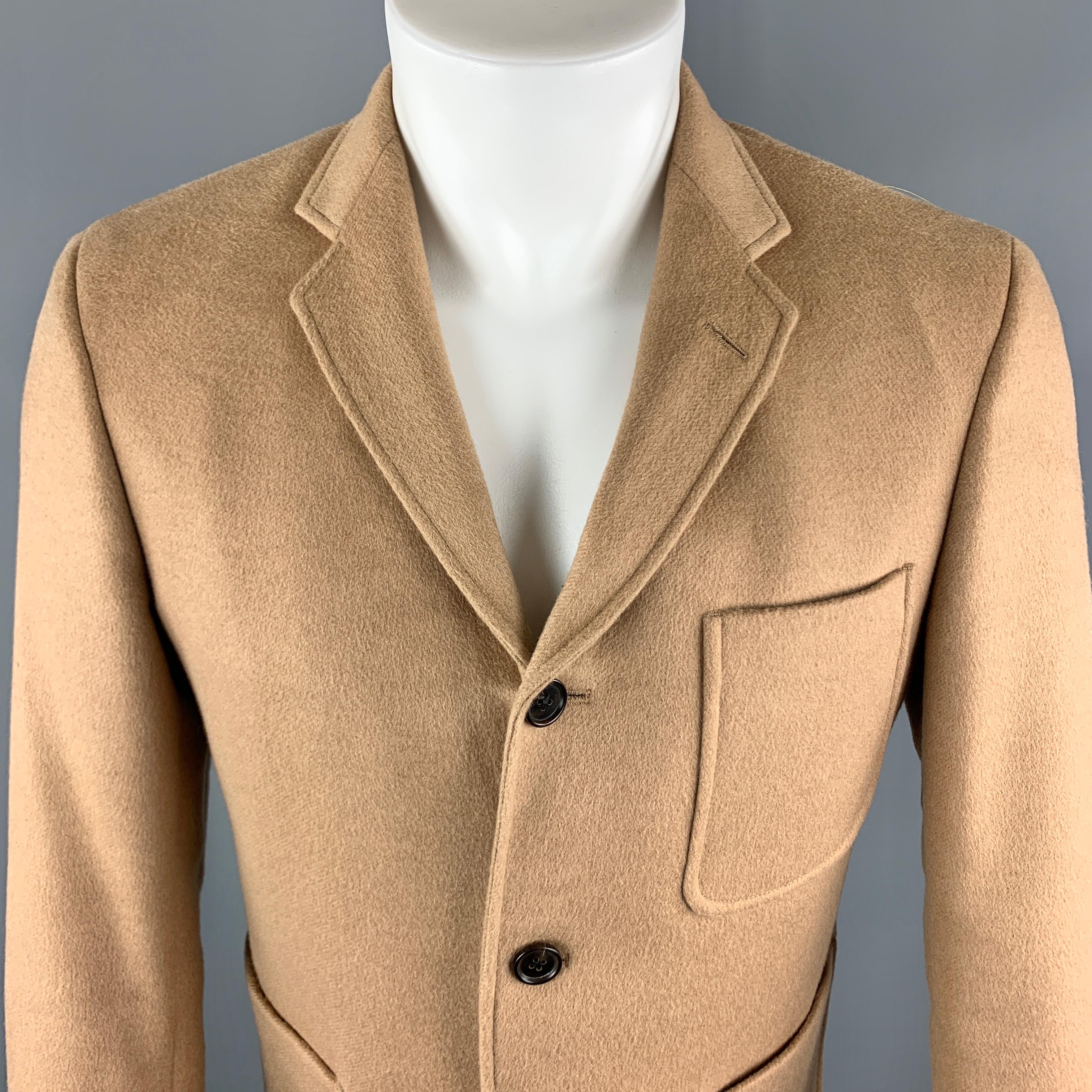 BLACK FLEECE Sport Coat comes in a tan camel hair material, with a notch lapel, single breasted, three buttons at closure, patch pockets, buttoned cuffs, a single vent at back, unlined. Made in USA.

Excellent Pre-Owned Condition.
Marked: