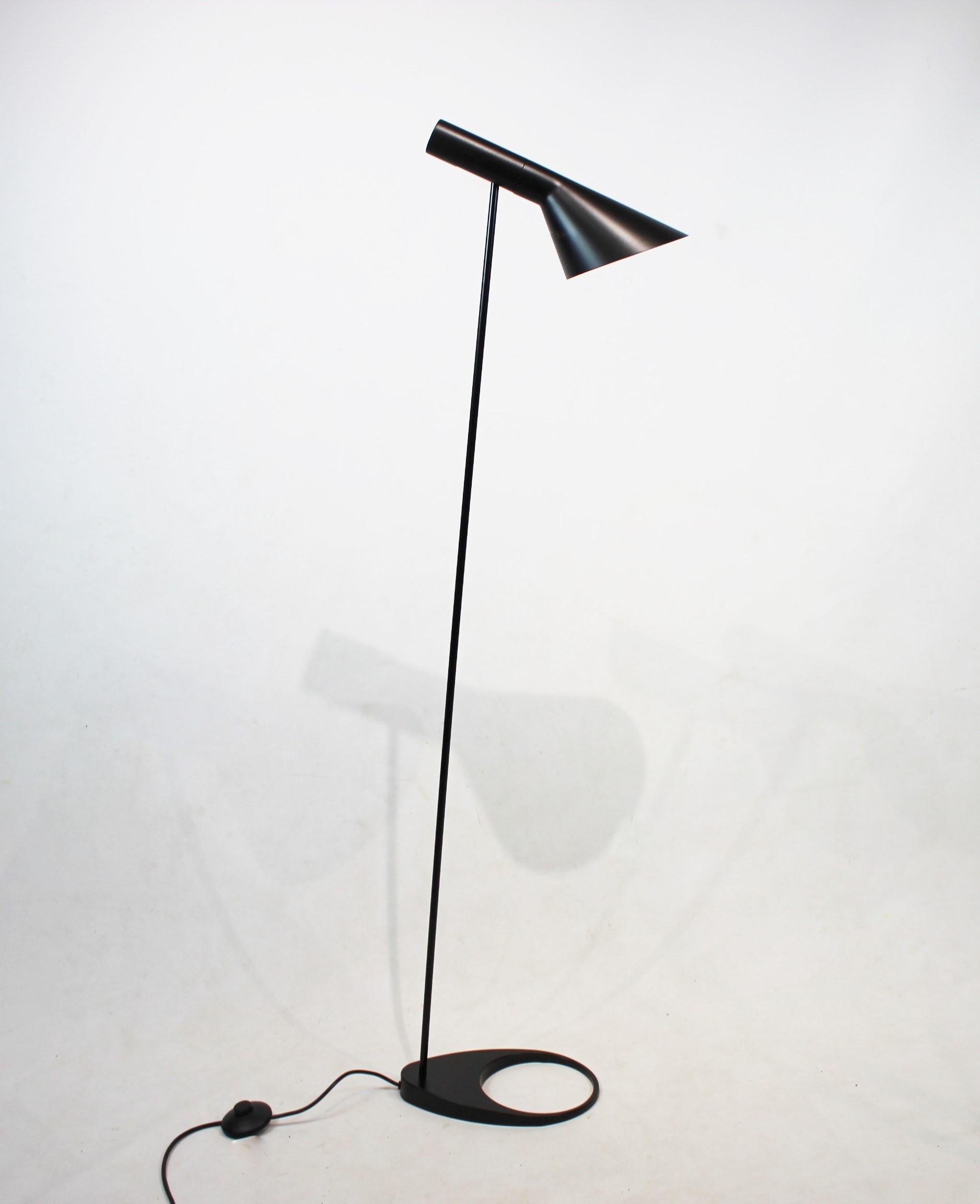 Questa lampada da terra nera, disegnata da Arne Jacobsen nel 1957 e prodotta da Louis Poulsen, porta con sé l'autenticità del modernismo danese e la funzionalità. La filosofia del design di Jacobsen si concentrava sulla creazione di un'armonia tra