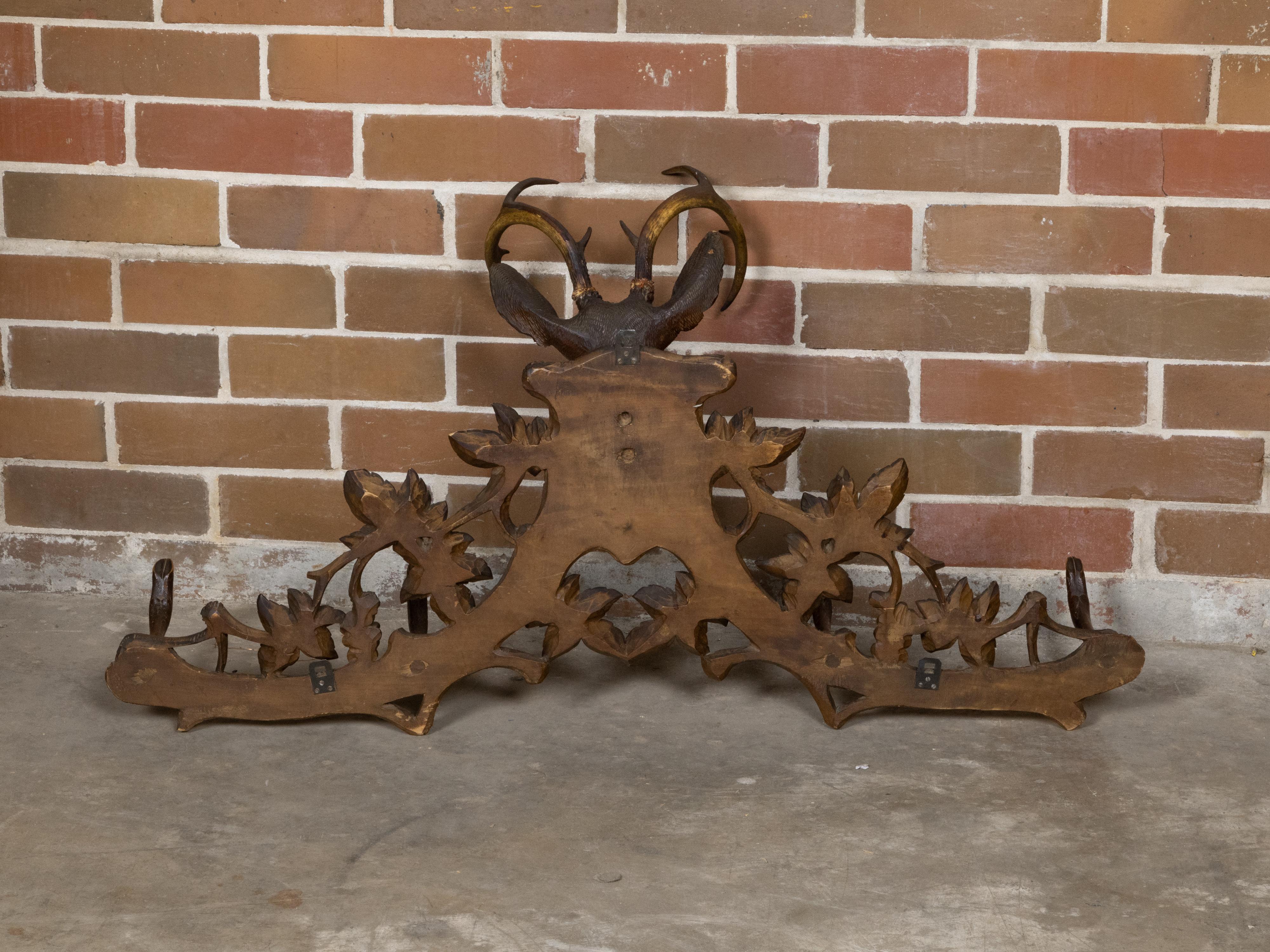 Perchero o sombrerero de pared tallado a mano de la época de la Black Forest, de hacia 1880, que representa un majestuoso ciervo con cornamenta rodeado de parras. Este perchero o sombrerero de pared tallado a mano de la época de la Black Forest, de