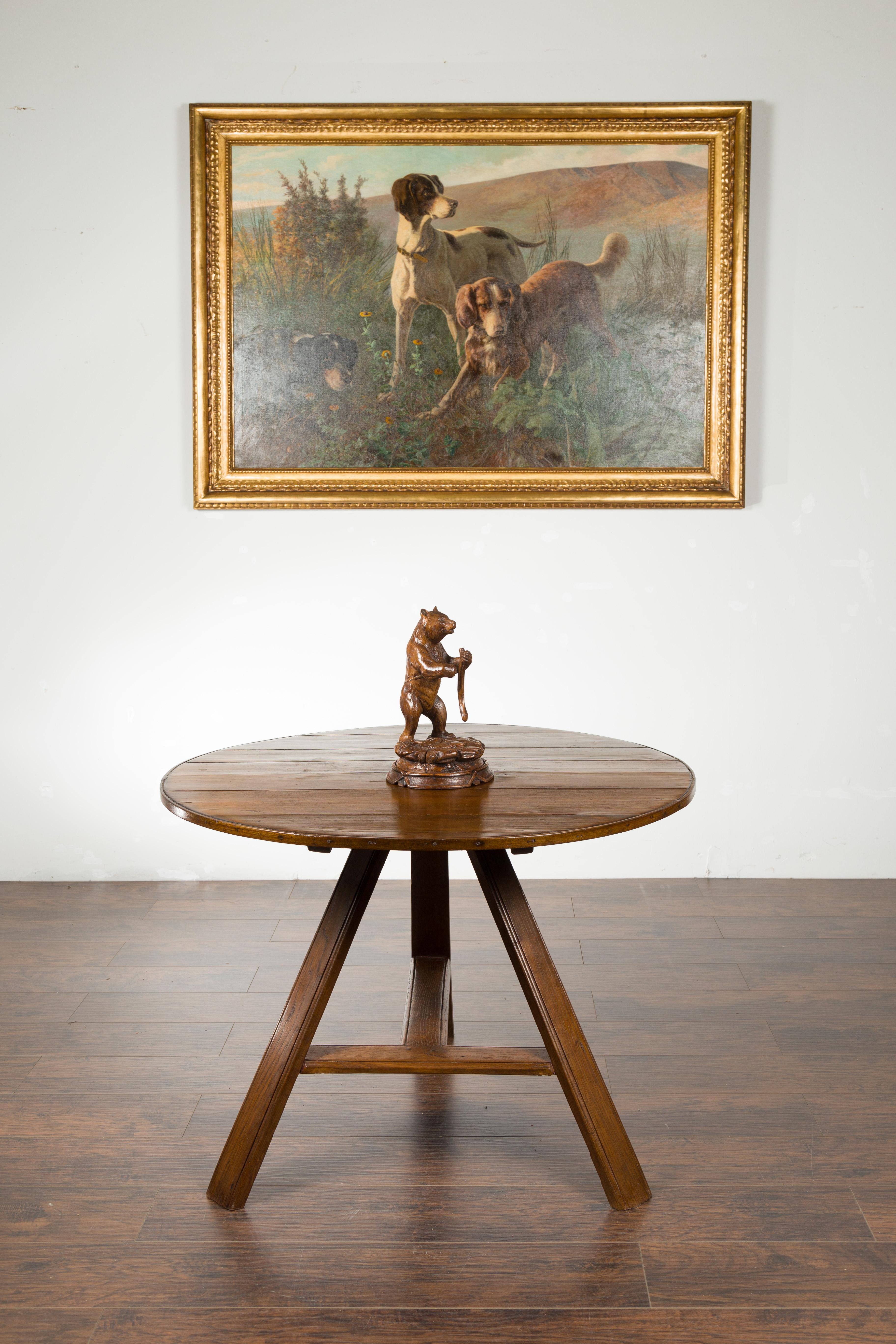 Eine geschnitzte Schwarzwälder Holzskulptur aus dem späten 19. Jahrhundert, die einen auf einem runden Sockel stehenden Bären darstellt. Diese im letzten Jahrzehnt des 19. Jahrhunderts geschaffene Schwarzwaldskulptur zeigt einen Bären, der auf den