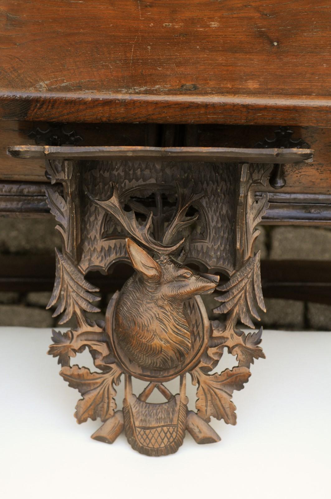 A Swiss Black Forest period oak wall bracket from the early 20th century, with hand carved stag motif. This early 20th-century Swiss Black Forest oak wall bracket, hailing from the scenic landscapes of Switzerland in the 1920s, captivates with its