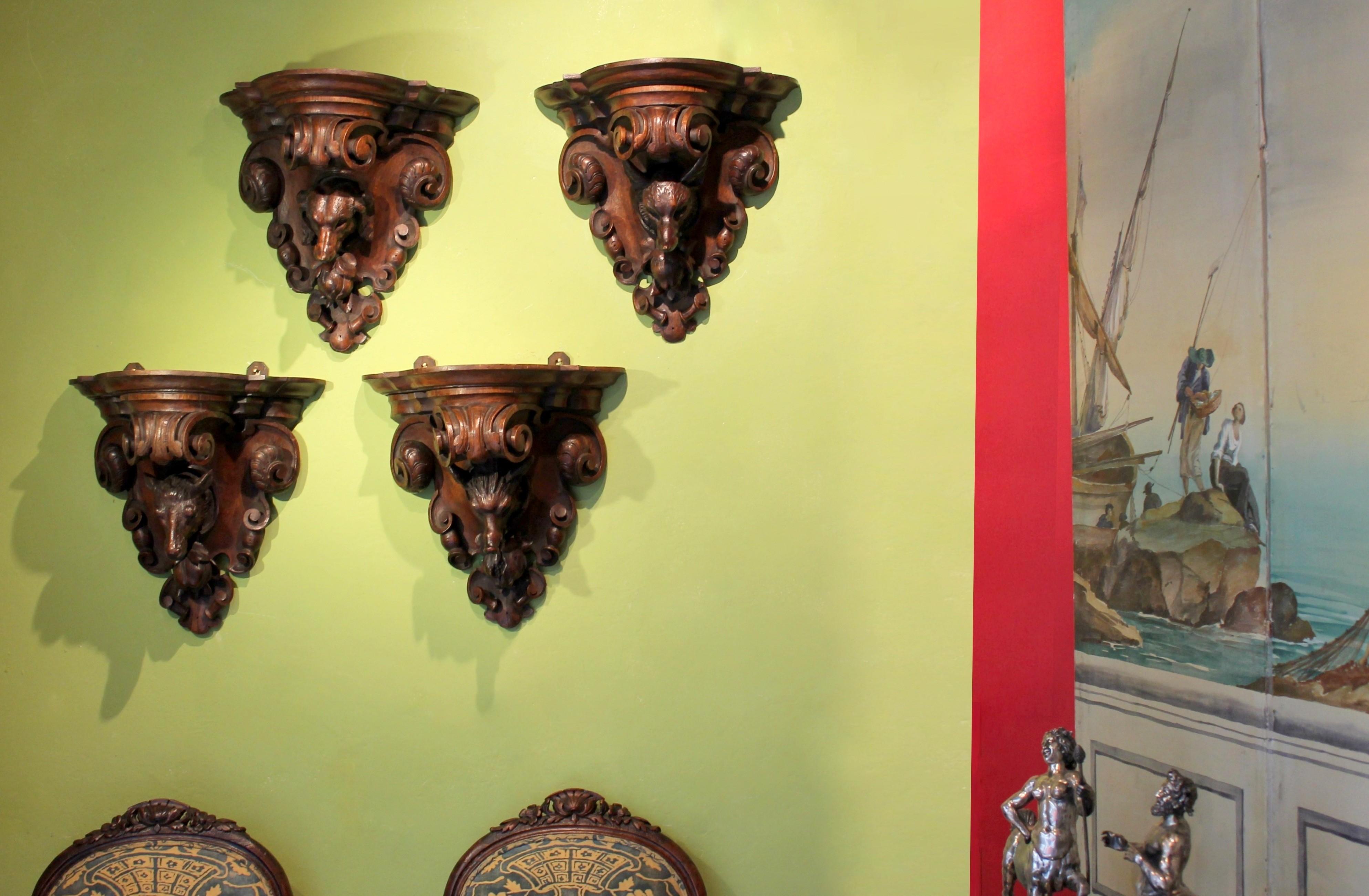 This antique and amazing set of four hand carved Black Forest solid oak wood wall brackets are impressively and deeply sculpted with hunting themed motifs. Under each deep hand carved shelf surface- wonderfully worked with curls, swirls and scrolls-