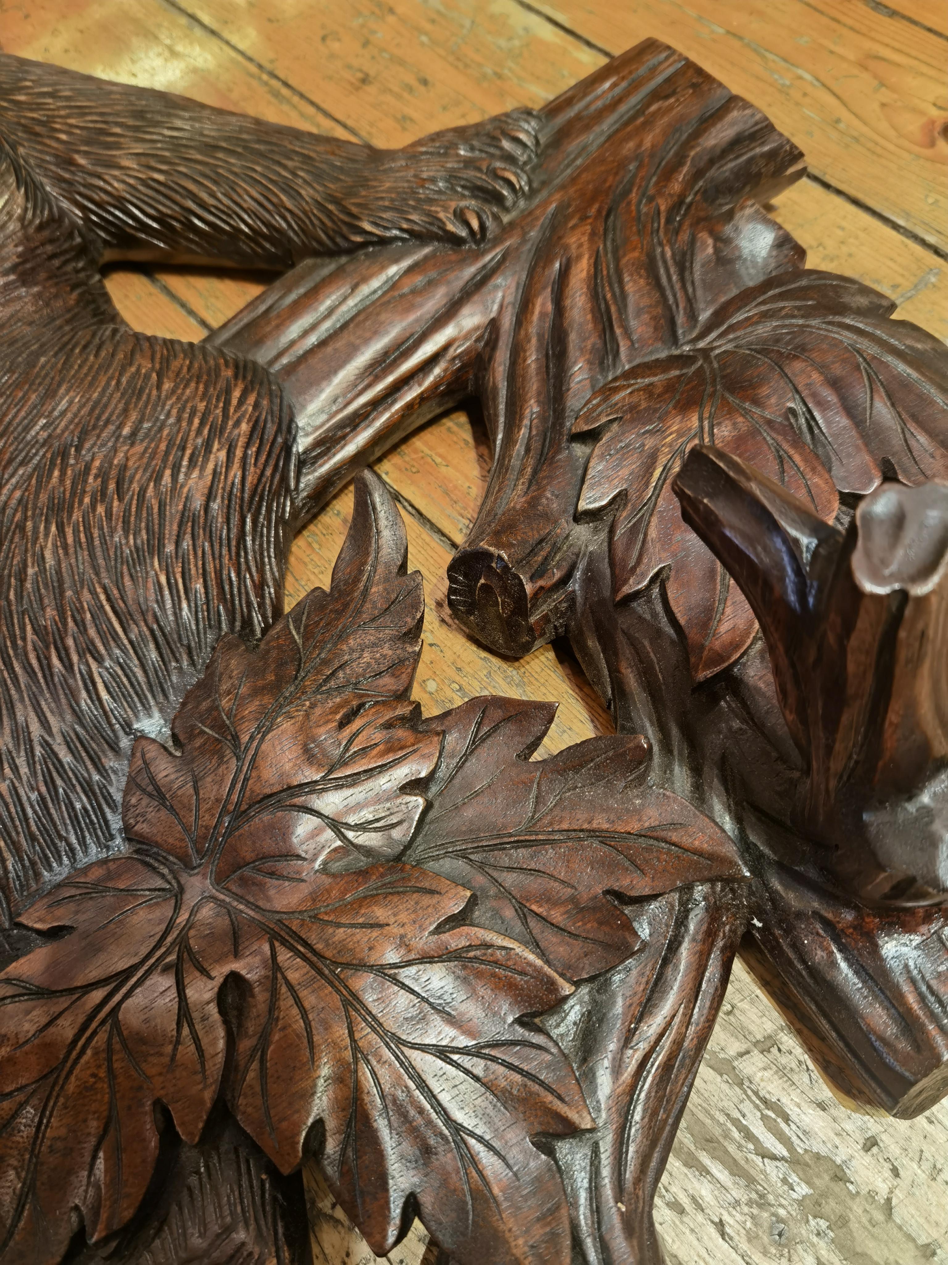 Grande armoire en bois massif de la Forêt Noire du 19e siècle, fabriquée à la main, avec 3 cintres et un miroir de forme ovale avec verre à facettes d'origine. Sculpté à la main dans du bois massif en forme d'ours naturaliste assis sur un arbre avec