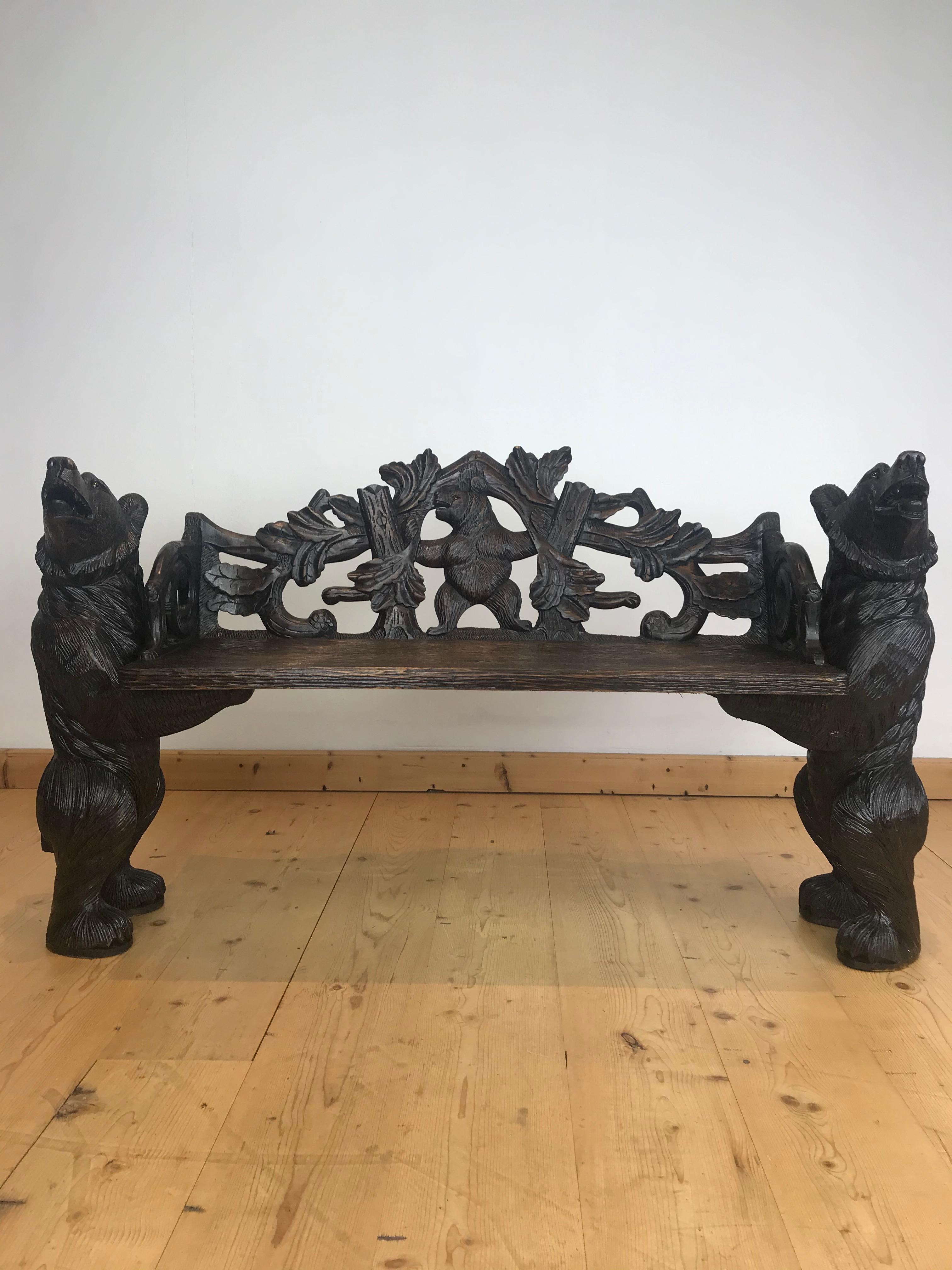 Black Forest style bear bench of the 20th century. This hall bench consists of 2 bears holding the bench. As well the bears as the bench are very detailed. The standing bears look impressive as they are strong to hold the seat. They have glass eyes.