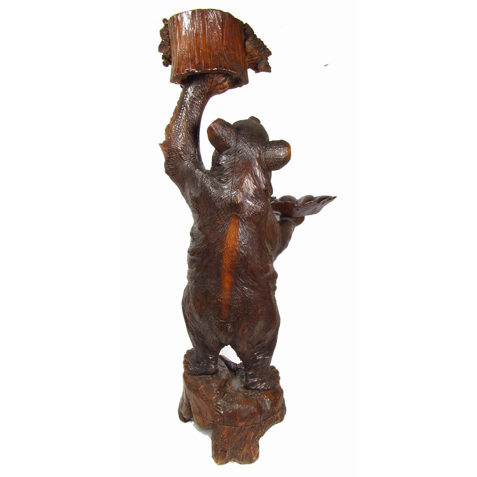 Antique Black Forest bear form carved walnut dumbwaiter, late 19th-early 20th century. Great patina. Interior of the mouth and claws polychromed, glass eyes. Measures: Height 41 1/4 inches, width 18 inches, depth 20 inches.
 