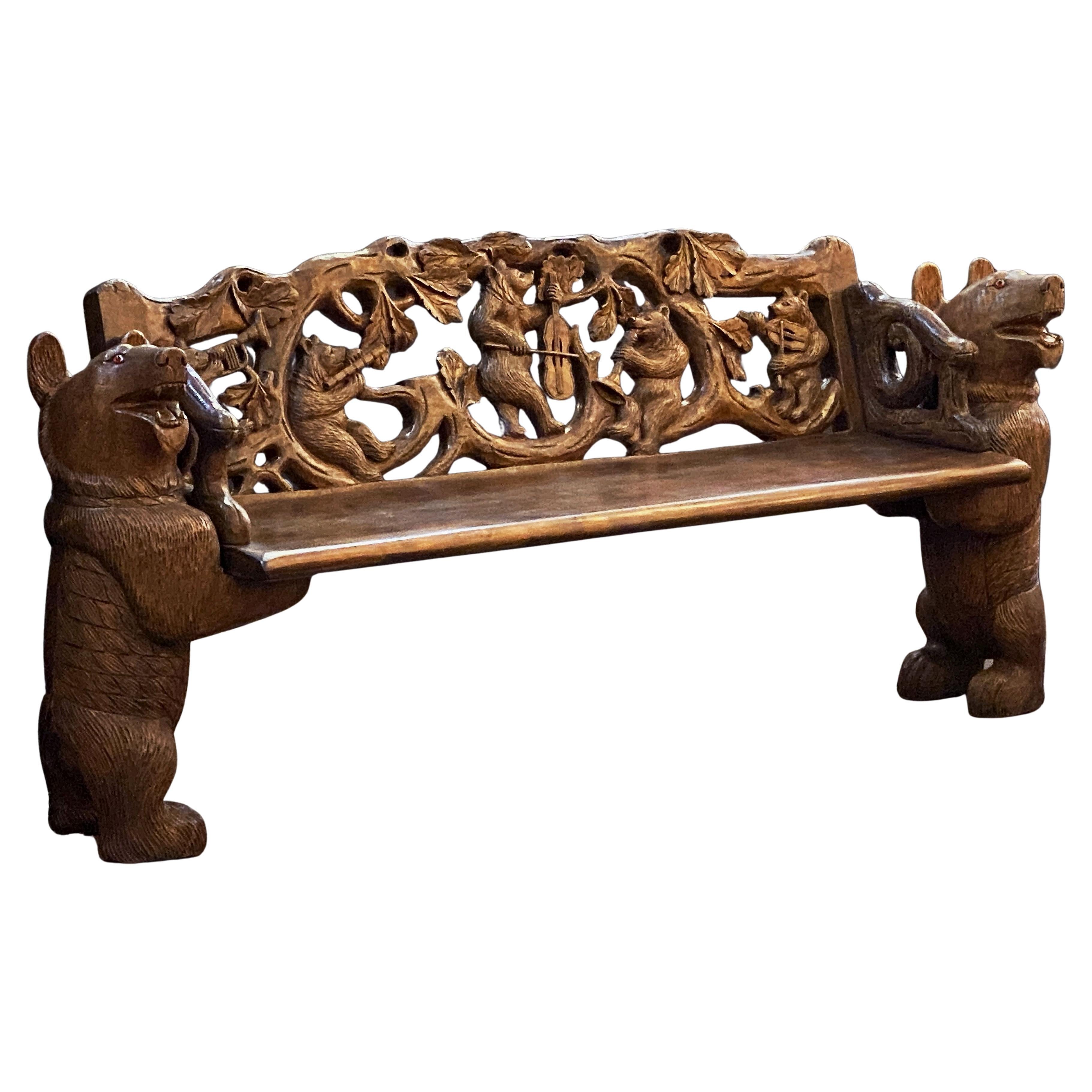 Rare banc en bois de tilleul sculpté de la Forêt-Noire, originaire de Suisse. Le dossier est sculpté en relief avec des branches et des feuilles et cinq petits ours batifolant en jouant des instruments de musique. Le siège est une planche de bois