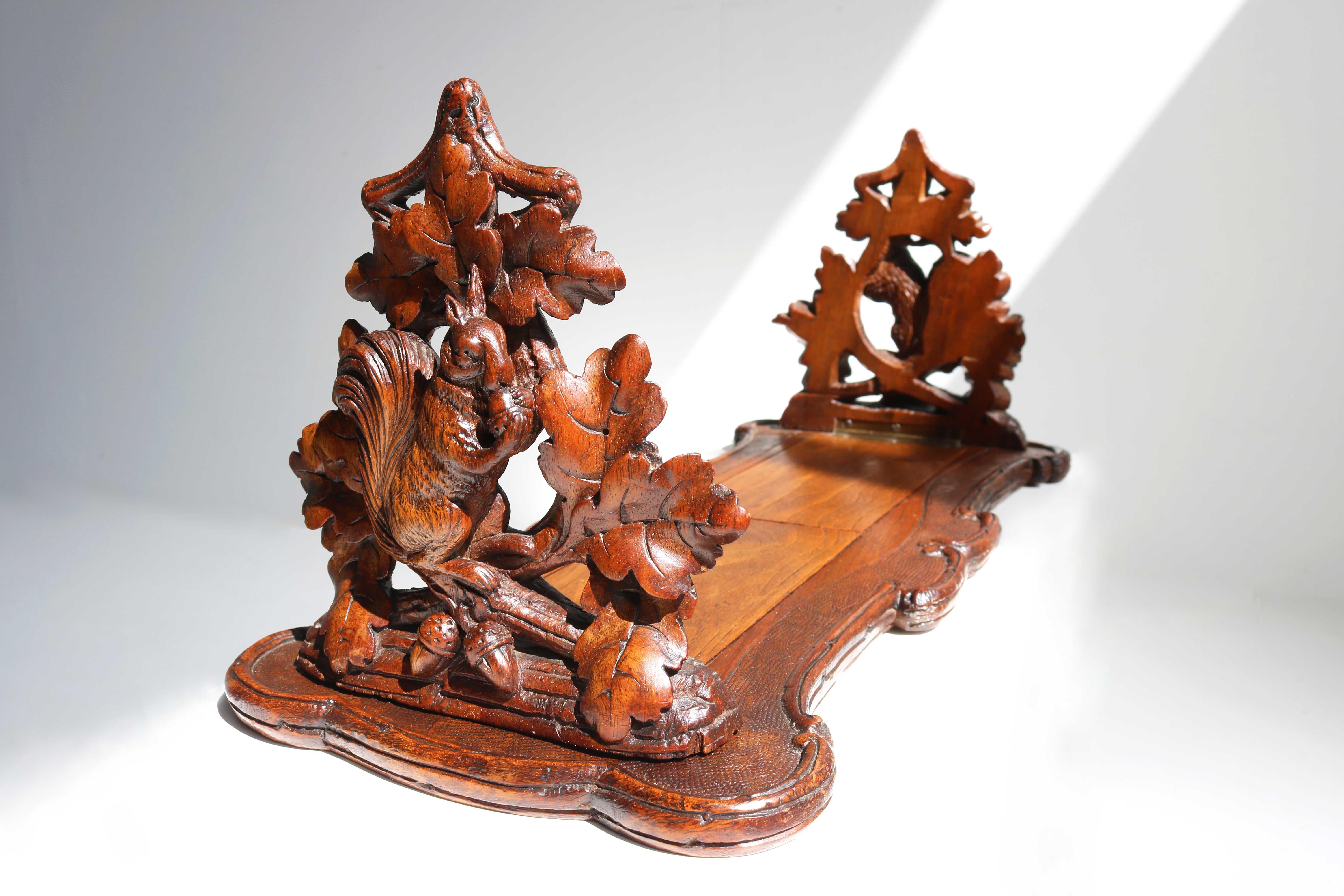 Antiquelate 19th century black forest books rack/ book shelf with folding squirrels and acorn leaf bookends hand carved Swiss

Gorgeous 19th century antique Black Forest bookstand with sliding and folding bookends, hand carved from Switzerland, is