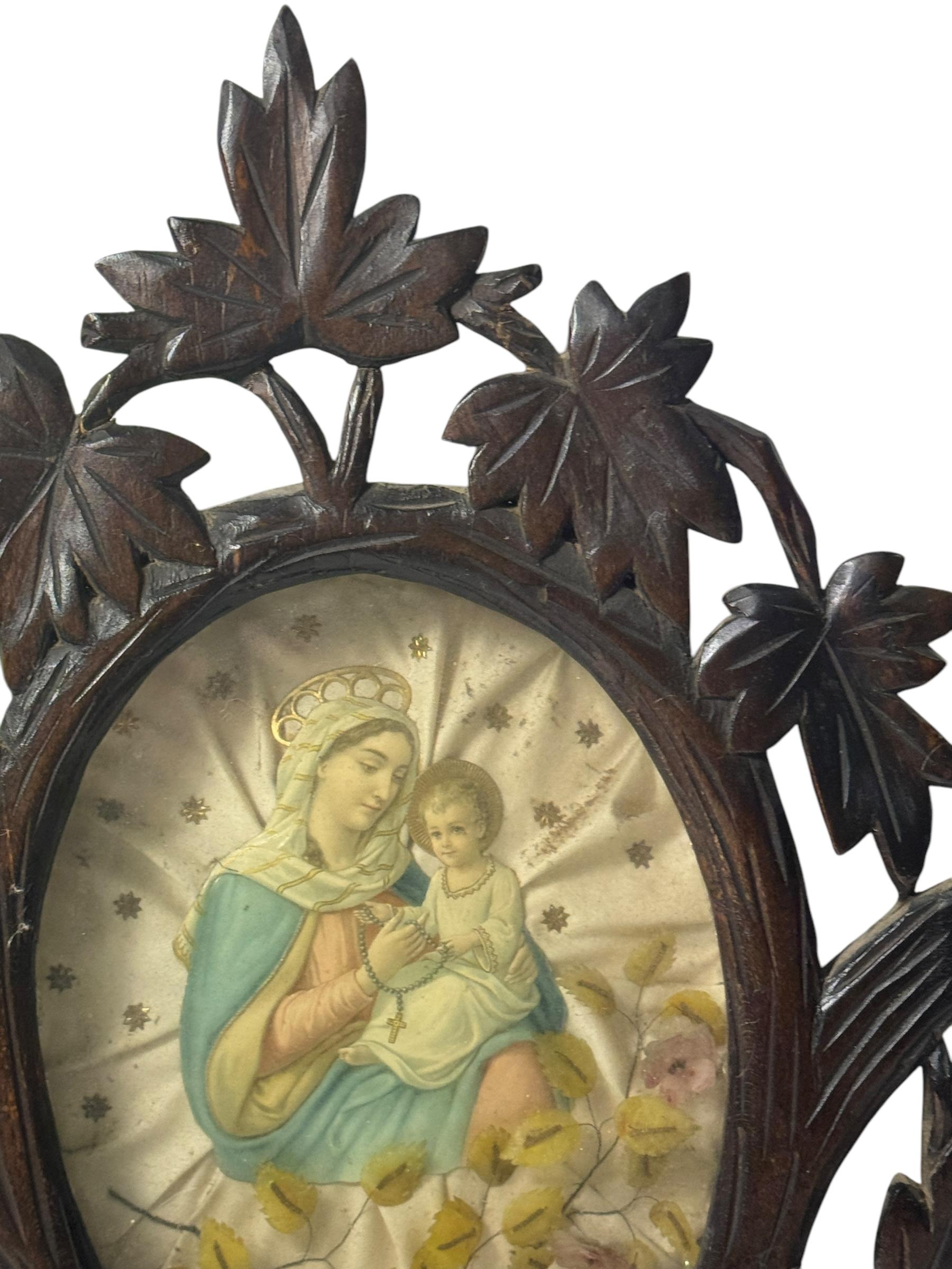 This beautiful wall decoration item is antique, old and beautiful.
It was made from carved wood, some fabric, glass and a Mary with Jesus child die cut scrap in the quiet of the Black Forest and comes from the Austrian Alpine region. The Carving is