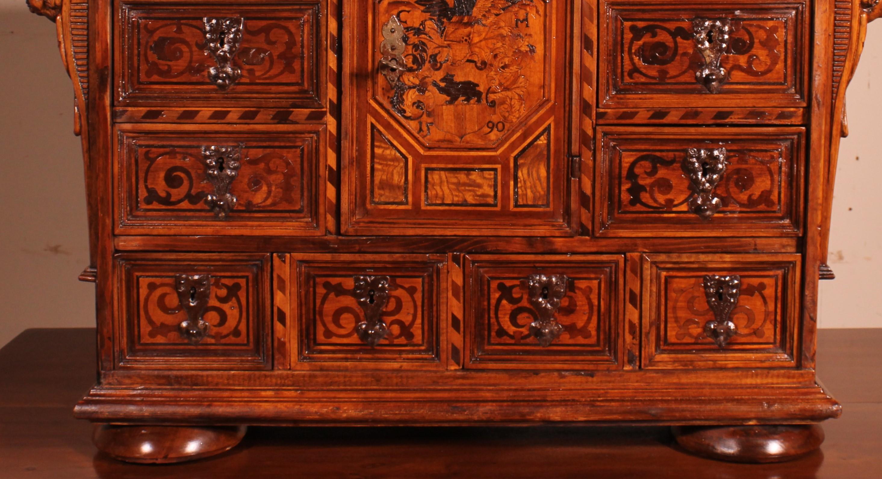 Sehr schöner deutscher Schrank wahrscheinlich Schwarzwald datiert 1590 in Nussbaum.

Sowohl die Schubladen als auch die Tür sind mit prächtigen gemeißelten Schlössern versehen. Das ist ein monumentales Werk und ein Zeichen für die schöne Herkunft