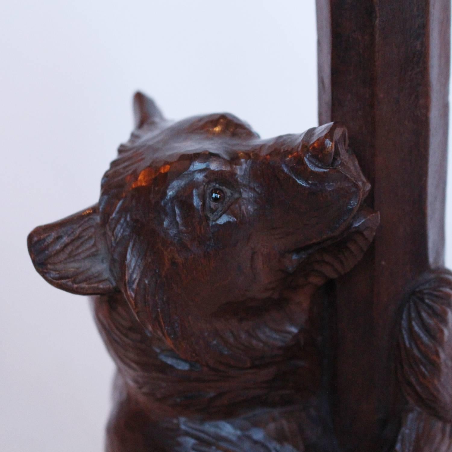 A Swiss Black Forest lime wood carved bear as a table lamp. Finely carved detail and original glass eyes.