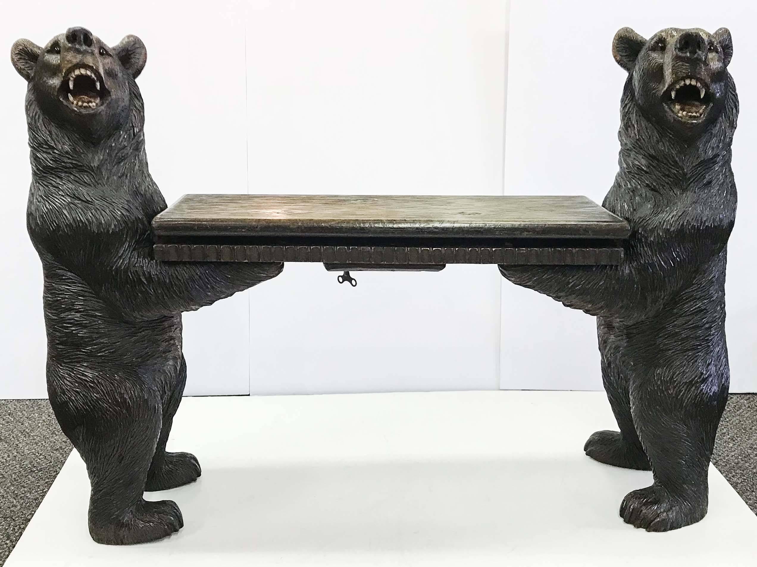 A hand carved Black Forest Bear Musical bench from Switzerland. The linden wood carving has beautiful patina and is full of detail, down to the whitened teeth and red tongue. The music box is activated to pay (only when wound with the original key)