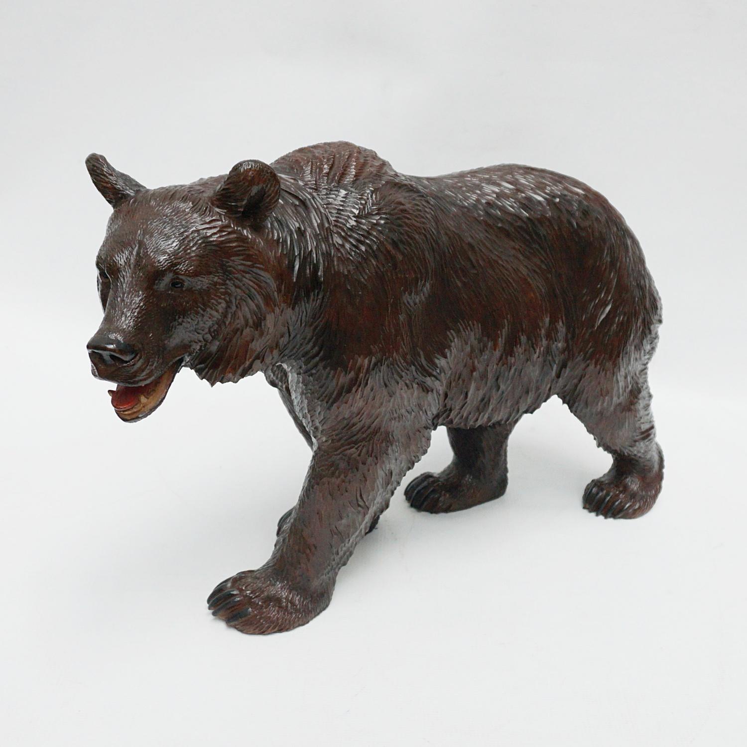 A Black Forest carved bear. Fine hand carved detail with original glass eyes. Linden wood.

Dimensions: H 27.5cm W 44cm D 14cm 

Origin: Swiss

Date: Circa 1890.