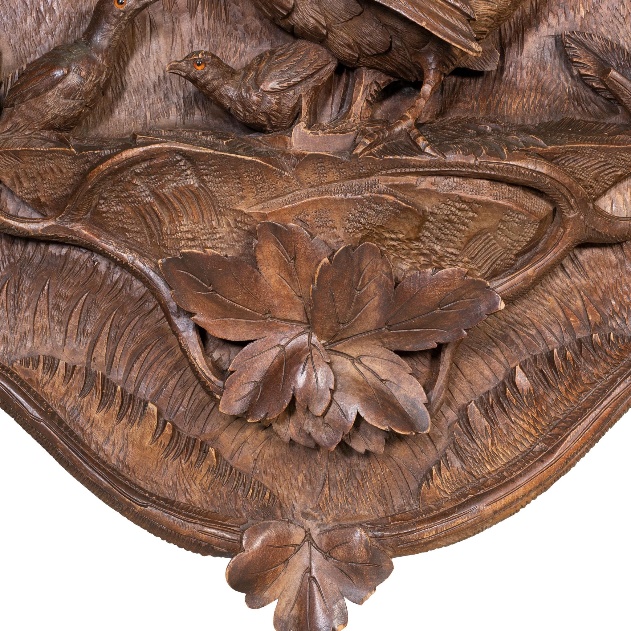 Plaque en noyer sculpté suisse représentant un gibier à plumes et deux poussins avec un motif de vignes et de feuilles. Fait partie de la Collectional de Brienz mais n'a pas été publiée.

Période : vers 1920
Origine : Suisse
Taille : 17