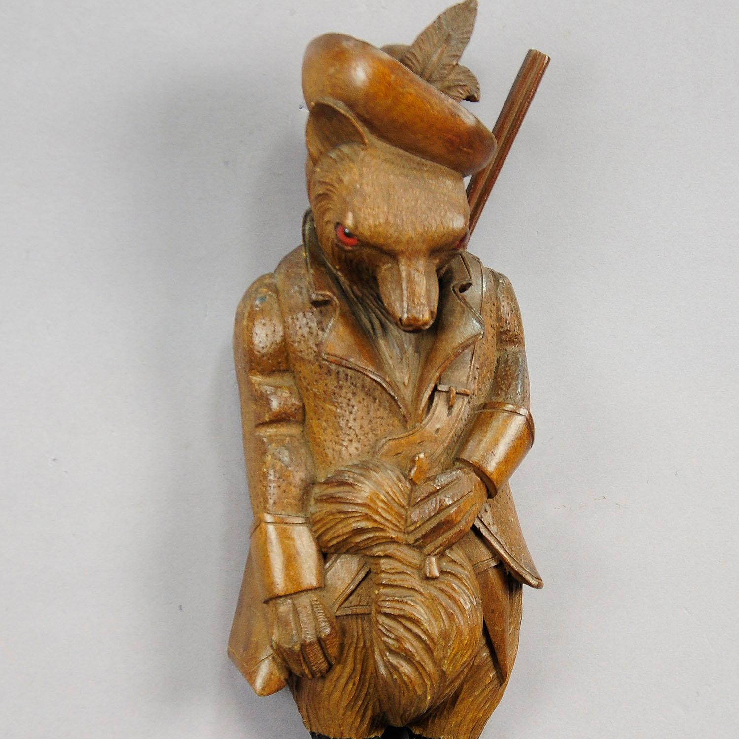 A hand carved cabin decor style coat hook or whip holder showing a fox with a gun. With wooden carved chamois horns. Carved in brienz, circa 1890.

Measures: Width 5.12