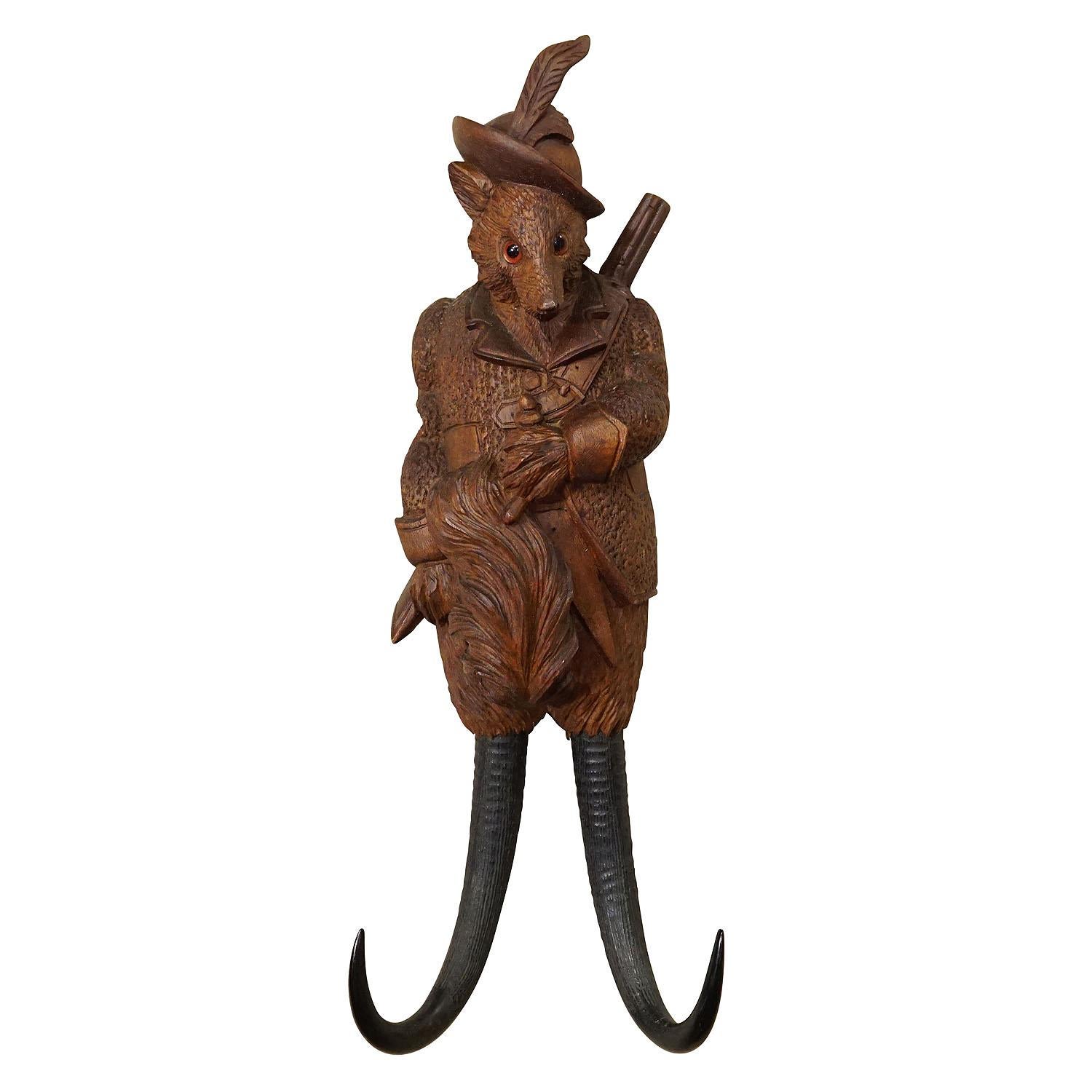 Black Forest Carved Fox Whip Holder or Wall Hook ca. 1900s

A handcarved cabin decor style coat hook or whip holder showing a fox with a gun. The hooks are made from genuine chamois horns. Handcarved in Brienz, Switzerland around 1900.

The