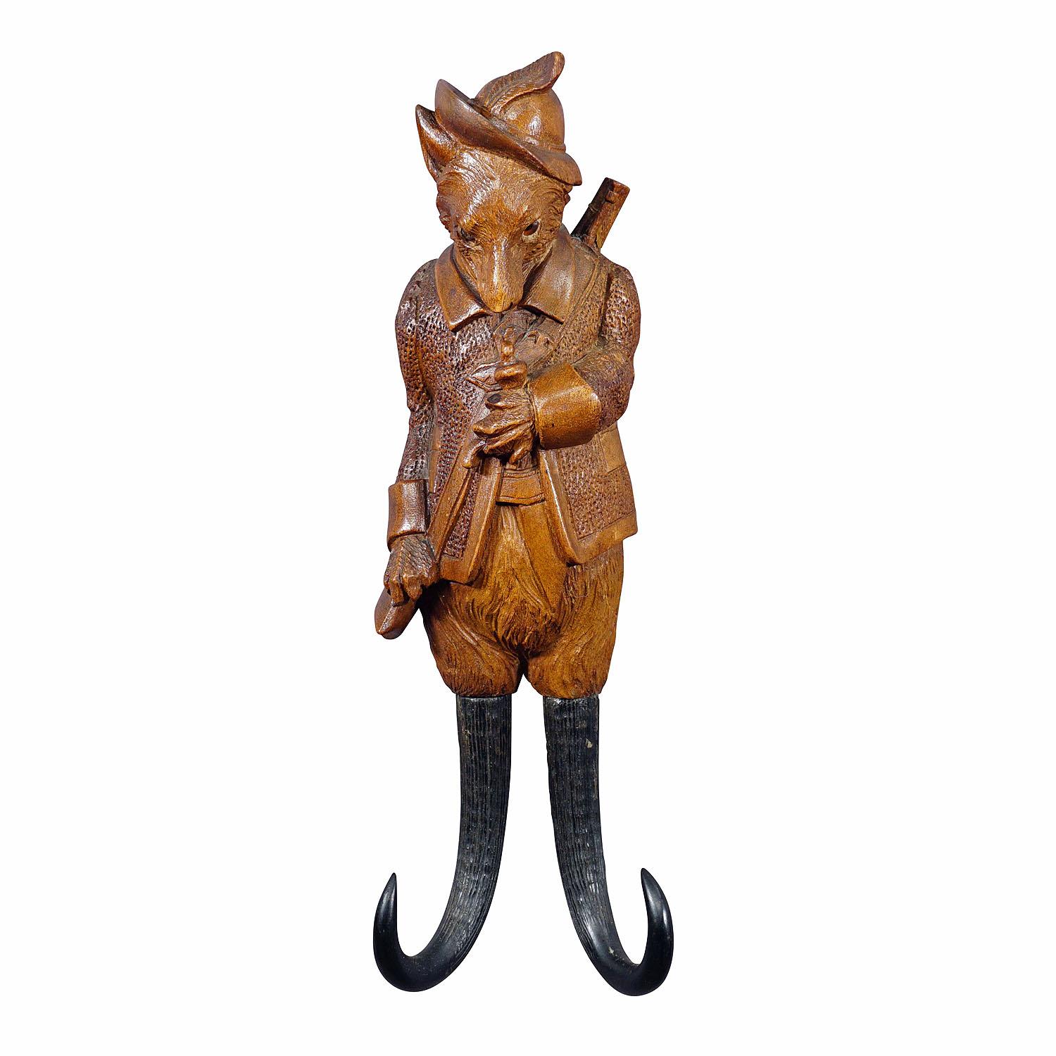 Porte-fouet ou crochet mural en forme de renard sculpté Black Forest

Porte-manteau ou porte-fouet sculpté à la main, de style décoratif de cabine, représentant un renard armé d'un fusil. Avec des bois de chamois véritables en guise de crochets.