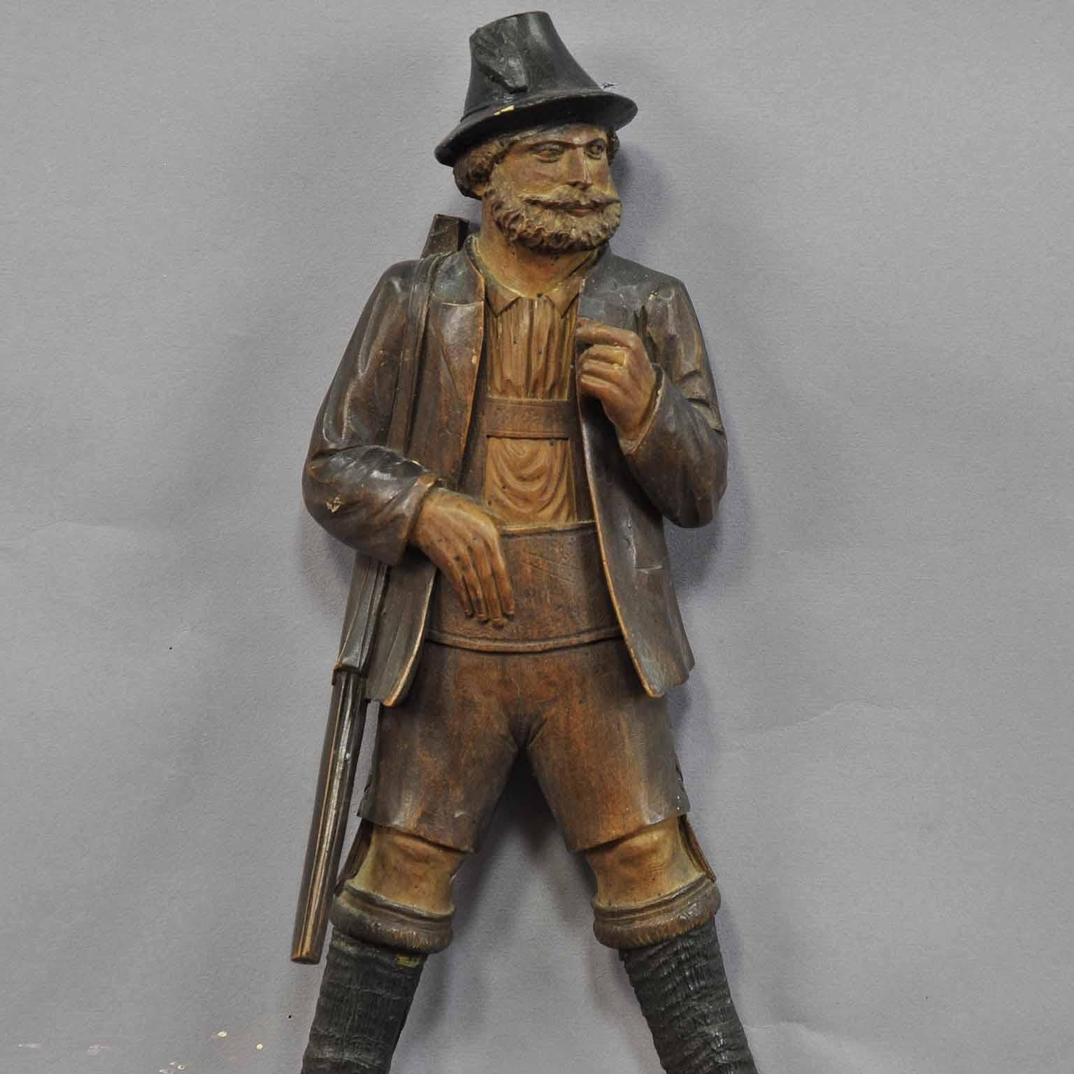A hand carved cabin decor style coat hook or whip holder showing a hunter with a gun. With real chamois horns. Carved in Brienz, circa 1890.

Measures: Width 6.1