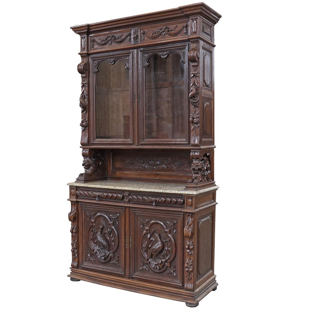 The furniture produced by woodworkers in the Black Forest style is renowned for its detailed carvings and this cabinet is no exception. This stepback-style hutch features dimensional carvings of partridges and couched lions. Carved drapery festoons