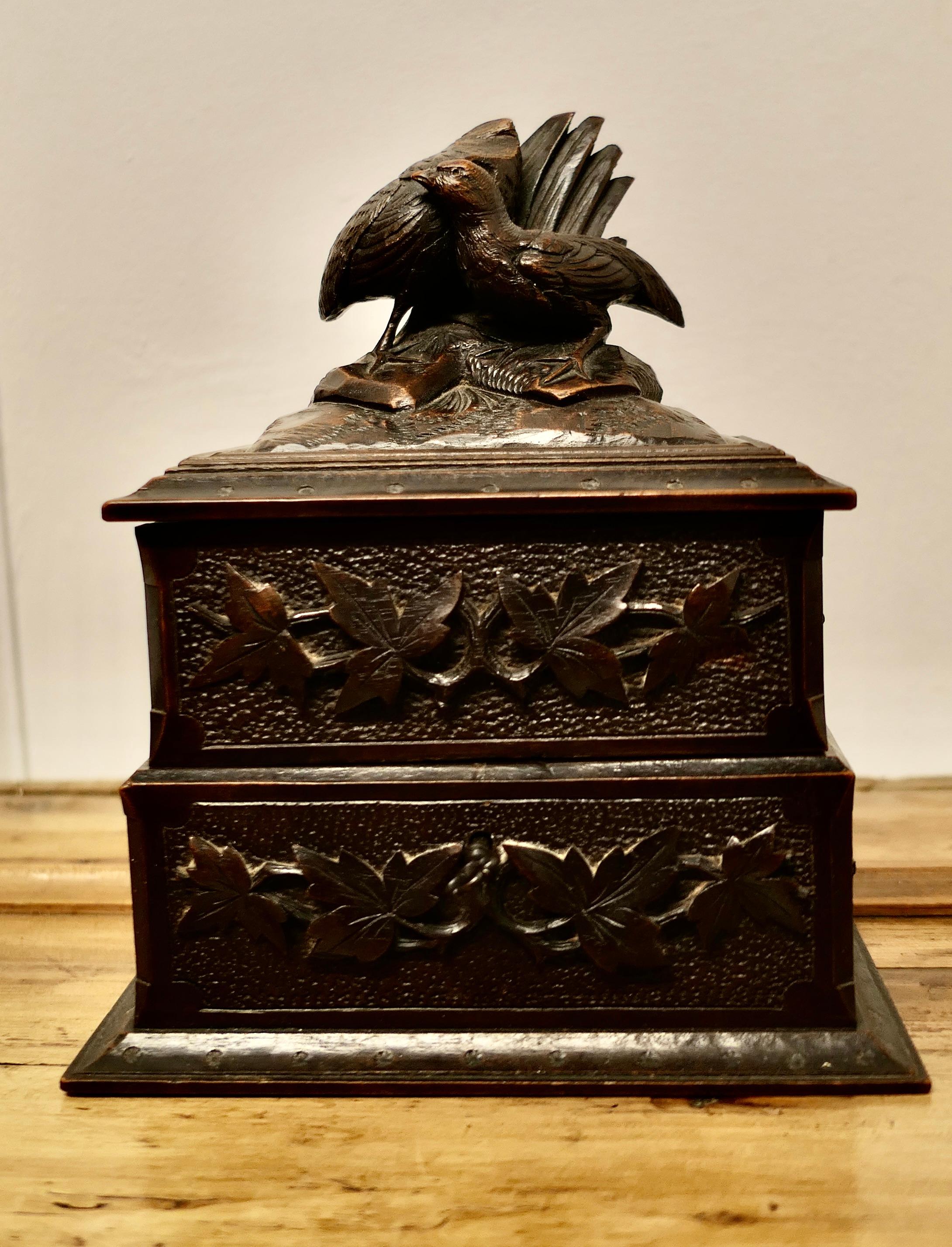 Black Forest Carved Walnut Jewellery Box 

A beautiful looking, well made piece, it is hand carved all over with woodcock and fauna decorations. Beneath the lid 2 lined compartments swing out to reveal a larger one below, these are all lined in deep
