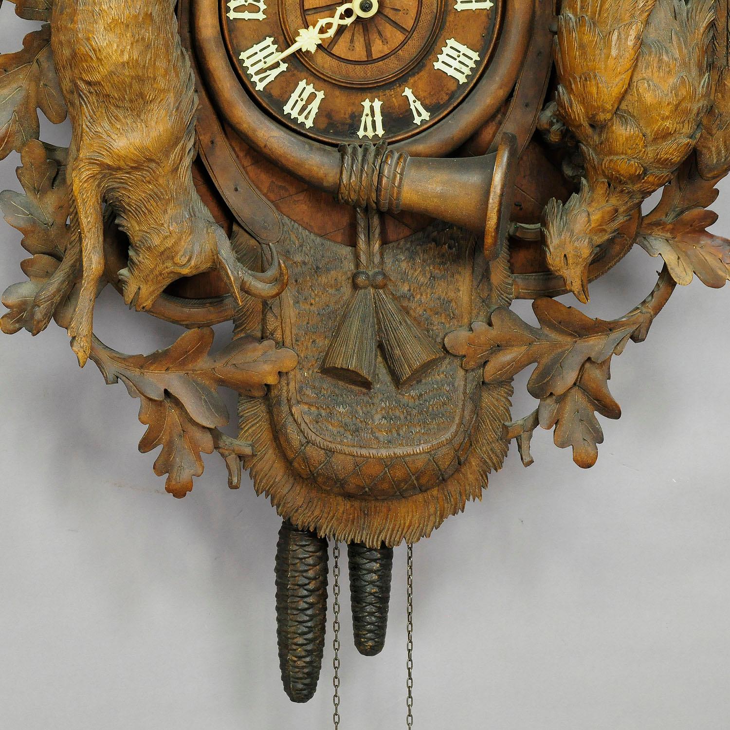 A great detailed hand carved wooden cuckoo clock, decorated with hunting accessories, oak leaves, hare, pheasant and a stag head on top. Black Forest, Germany, circa 1900. Clockwork in working condition, overworked by a clockmaker.
Measures:
Width