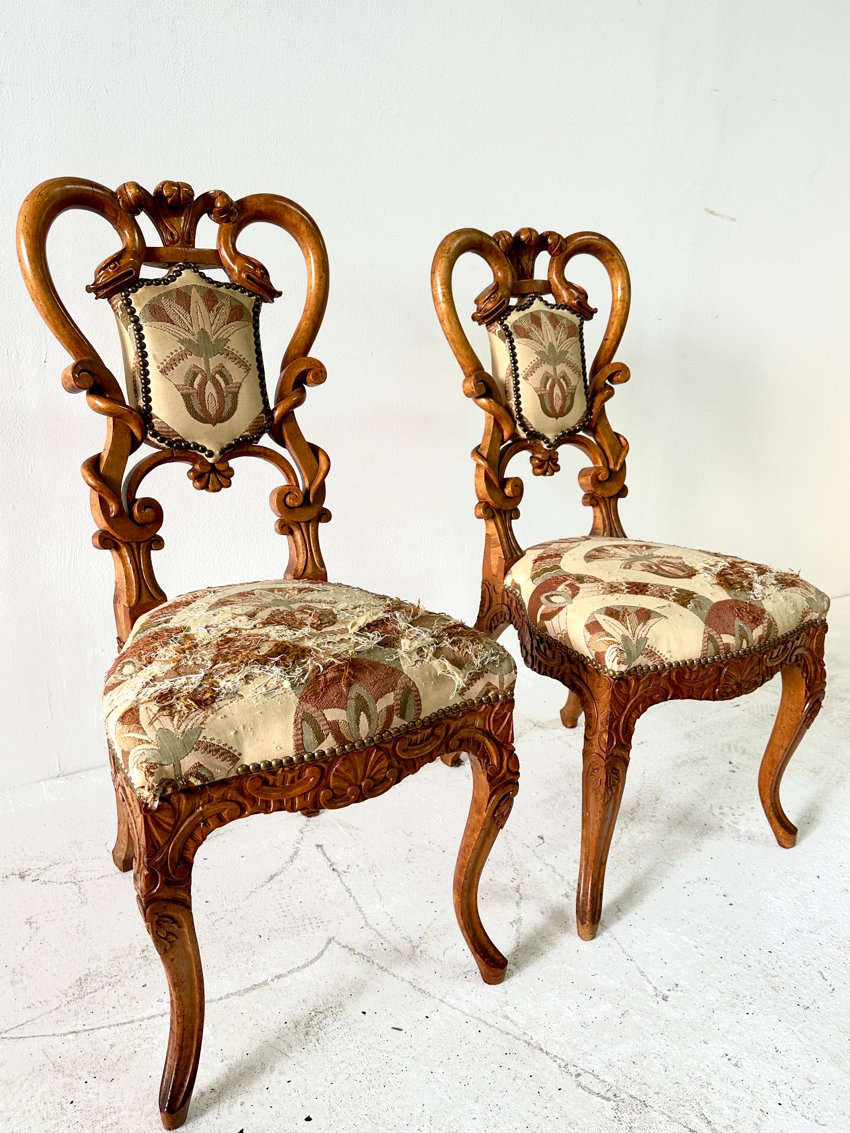 Ces chaises d'appoint sont un magnifique exemple de bois sculpté du sud de l'Allemagne et de l'Autriche, avec des détails étonnants, notamment des dragons mythologiques et de la flore.  Nous avons laissé le tissu d'origine qui est un brocart