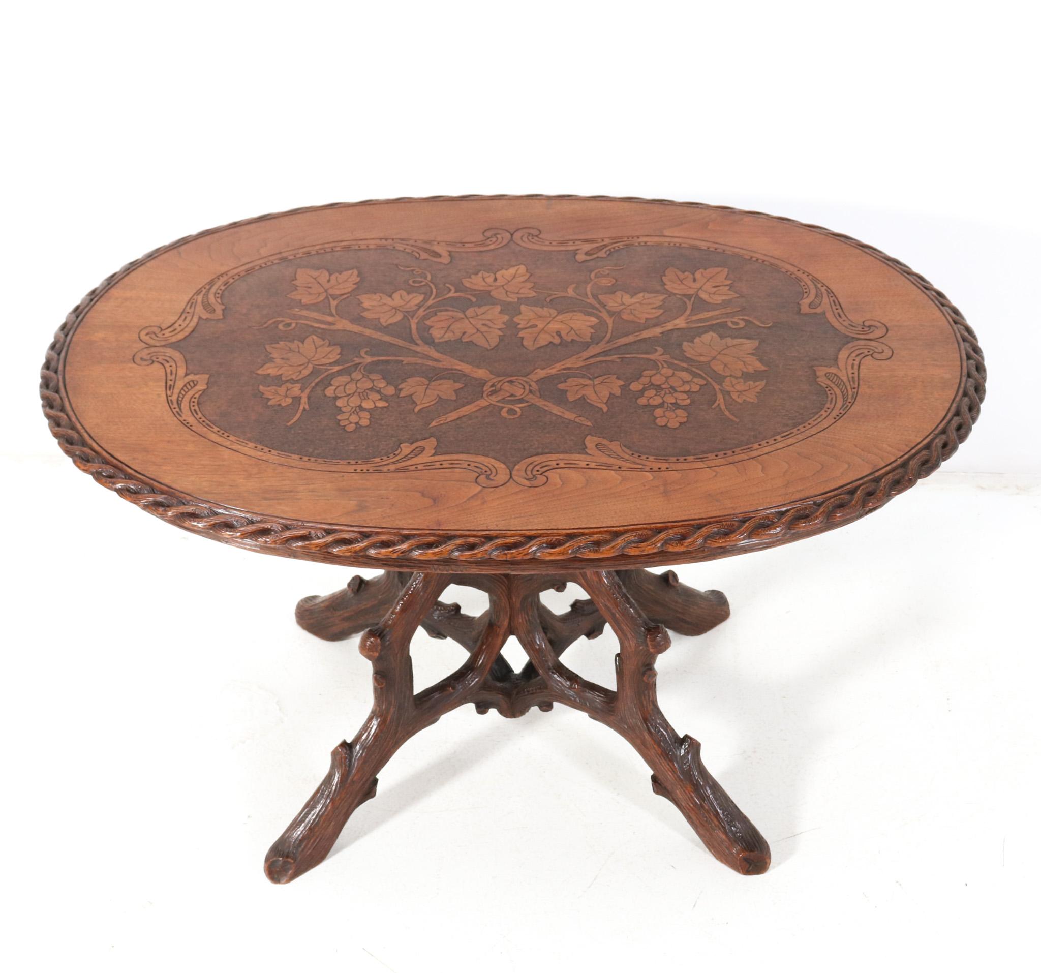 Magnificent and ultra rare Black Forest center table. Design by Matthijs Horrix for the famous Dutch cabinet makers Horrix Den Haag. Striking Dutch design from the 1880s. Solid hand-carved walnut base with original hand-carved and inlaid top. This