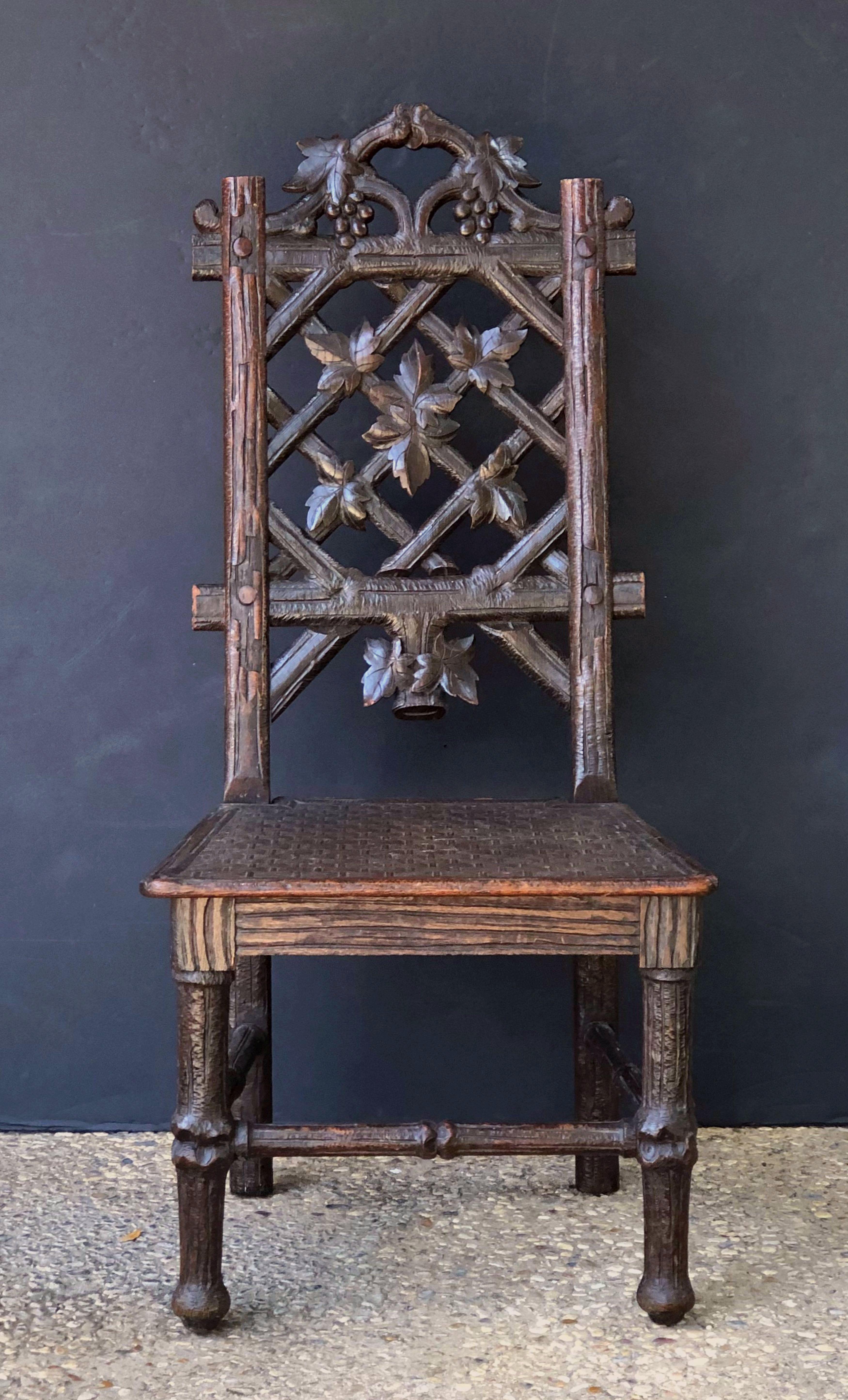 A fine Black Forest chair of carved oak from Switzerland, circa 1860, featuring a rustic trellis and grapevine back, the solid carved basket seat on rustic legs. 

Marion & Co. stamped on the back. 

Dimensions: H 39 1/2 inches x W 18 1/2 inches