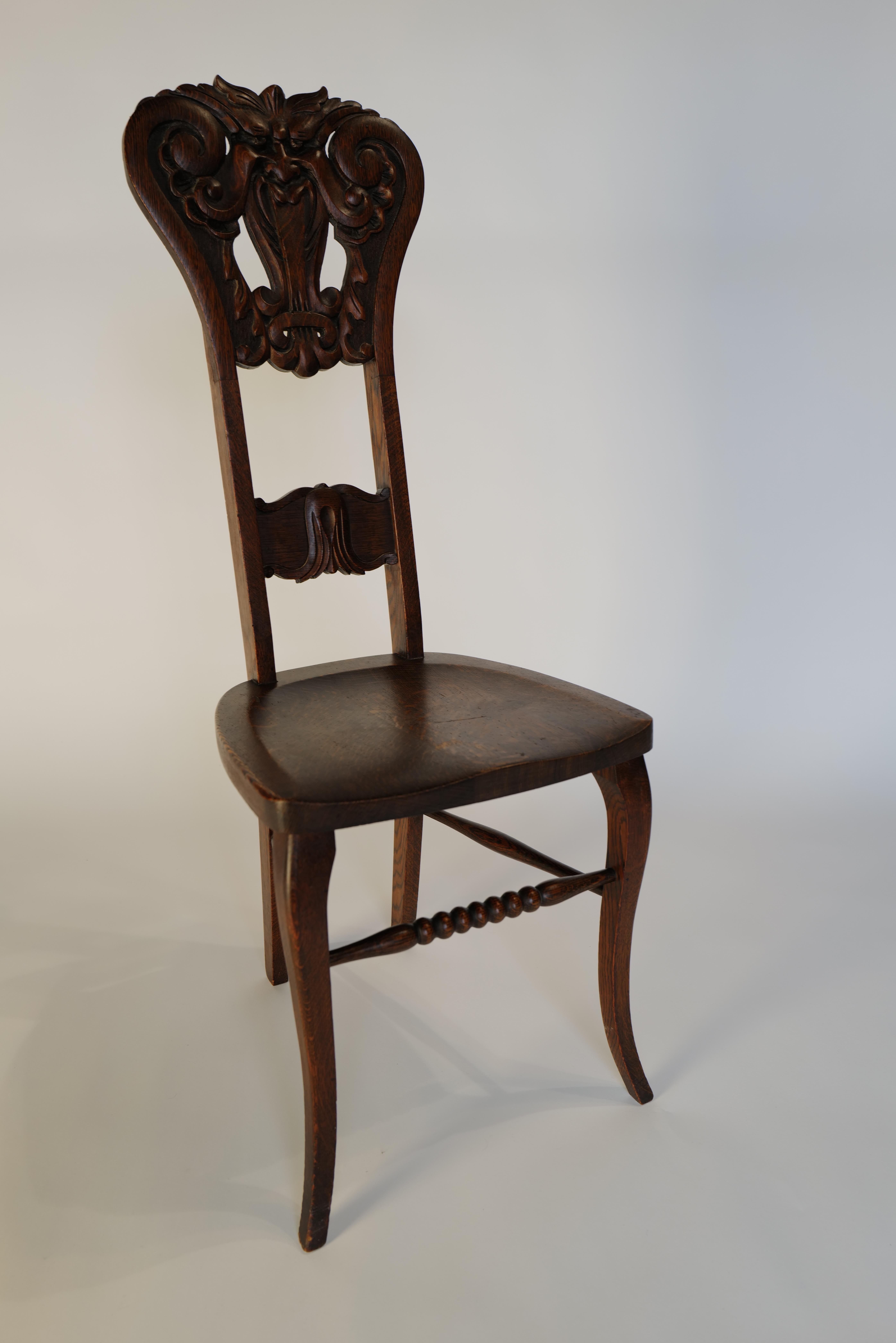 Whimsical Black Forest North Wind style carved face chair. Turned wood and carved detail in tiger oak. A wonderful addition in any interior.