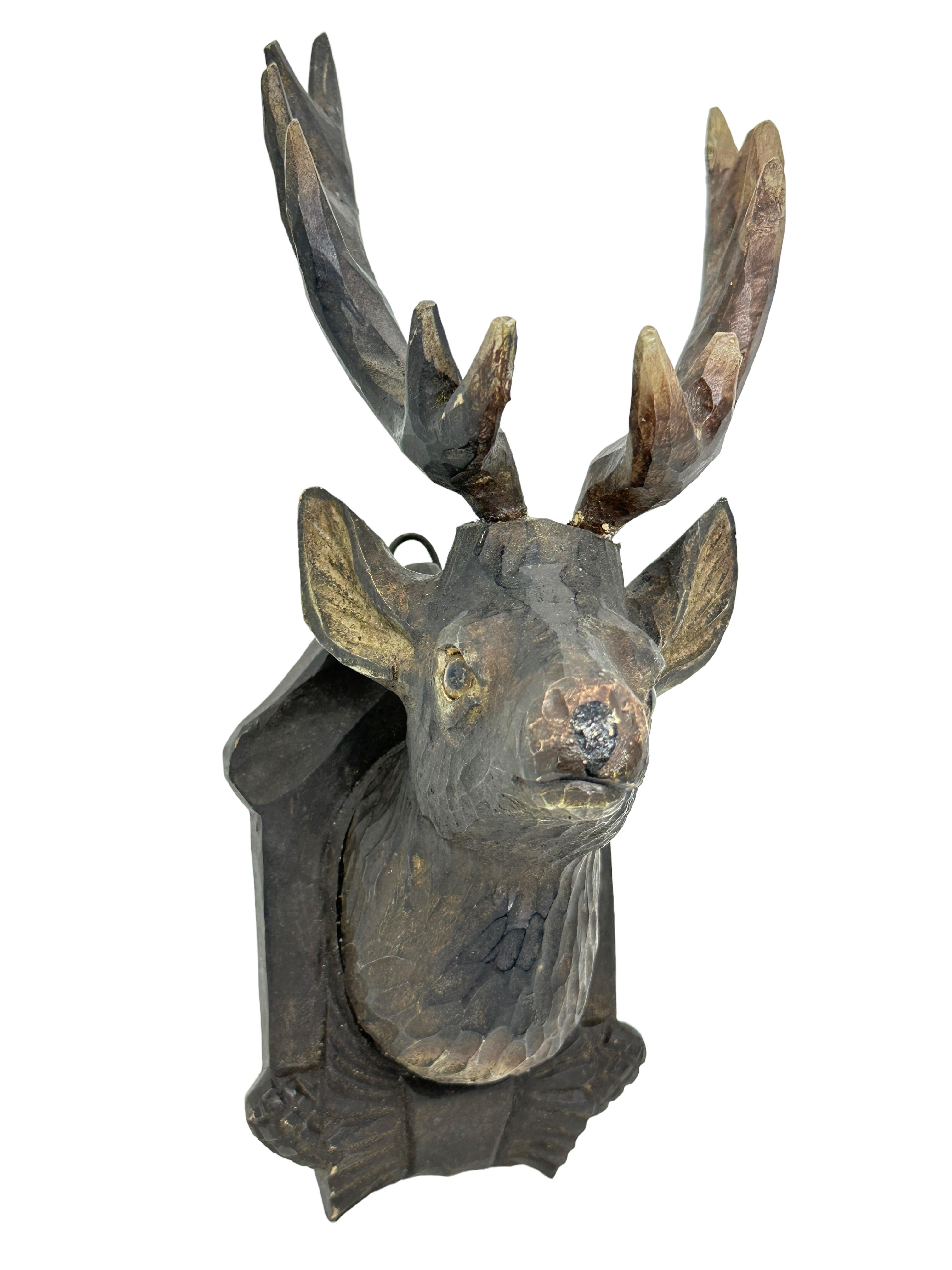 Une superbe décoration murale en bois sculptée à la main, de style Folk Art, avec une tête de cerf. Une pièce idéale pour créer une ambiance appropriée dans une salle de trophées ou le bureau d'un chasseur ou d'un bûcheron. Plus que probablement