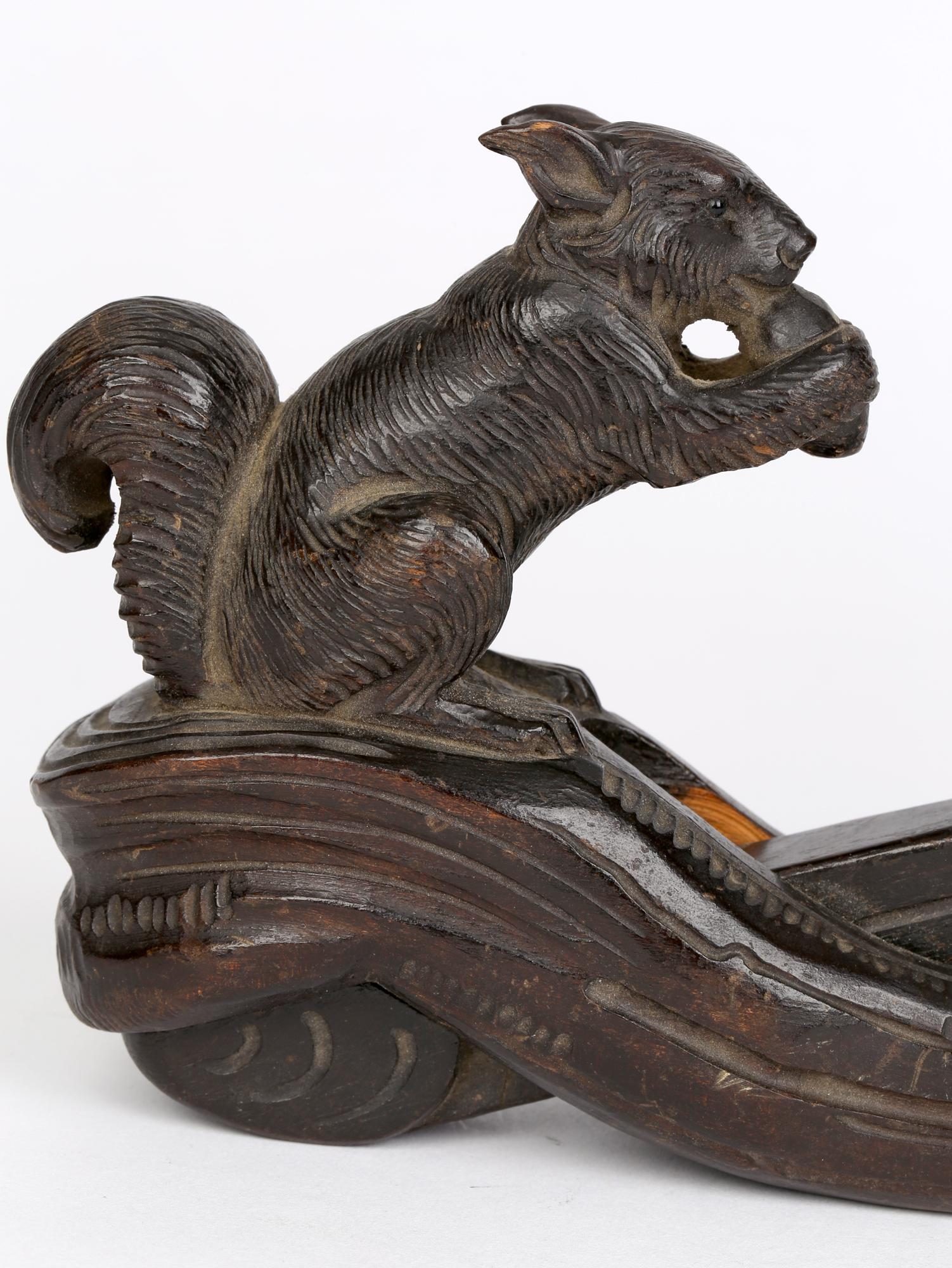 A rare antique German hand carved wooden nutcracker mounted with a squirrel made in the Black Forest and dating from around 1890. The nutcracker, probably made from pine and is carved in two sections which form a up and down pincer movement with a