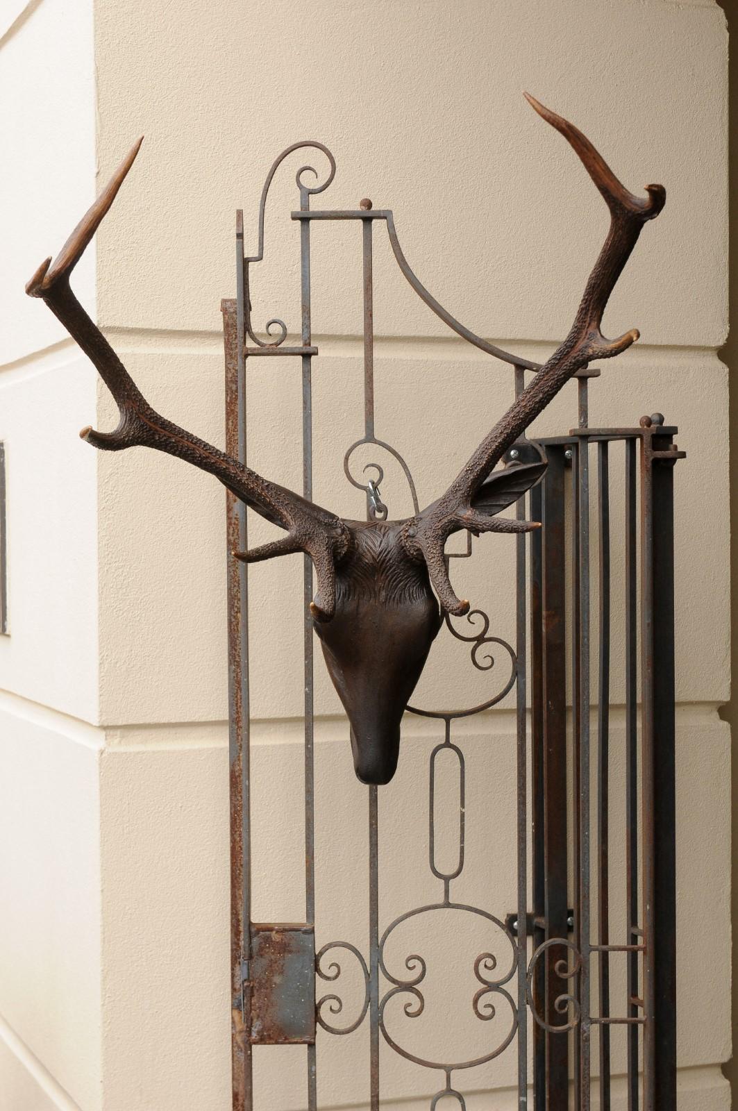 A Black Forest carved wooden stag head from the early 20th century with antlers. Born during the second decade of the 20th century, this charming hand carved stag head features a lovely facial expression. Attached to the head, two large authentic