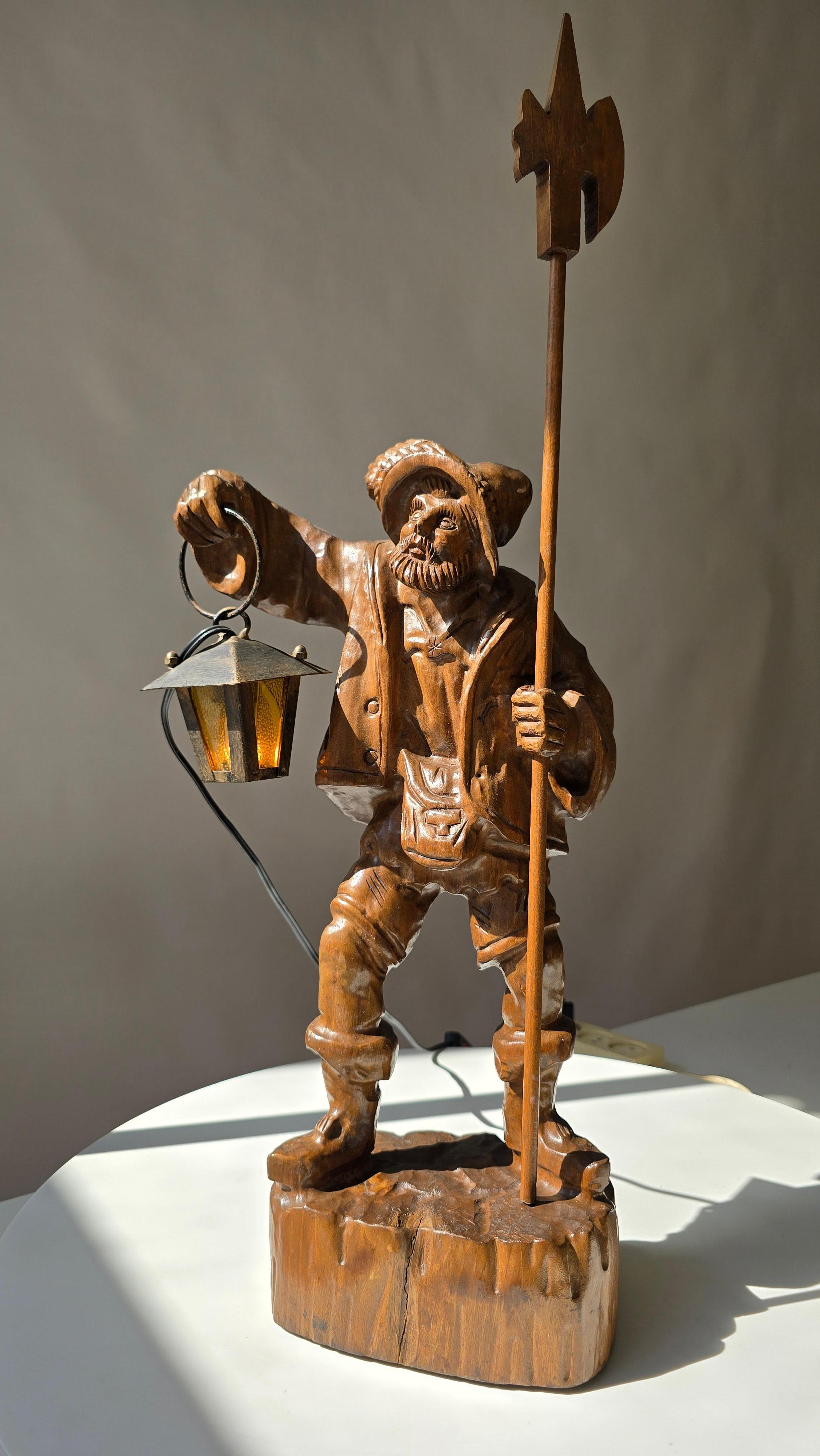 Charmante handgeschnitzte Schwarzwälder Holzlampe eines Nachtwächters mit Laterne, ca. 1950er Jahre.

Eine einzigartige handgeschnitzte Holzlampe im Schwarzwaldstil, die einen traditionellen Nachtwächter mit einer Laterne und einer Hellebarde