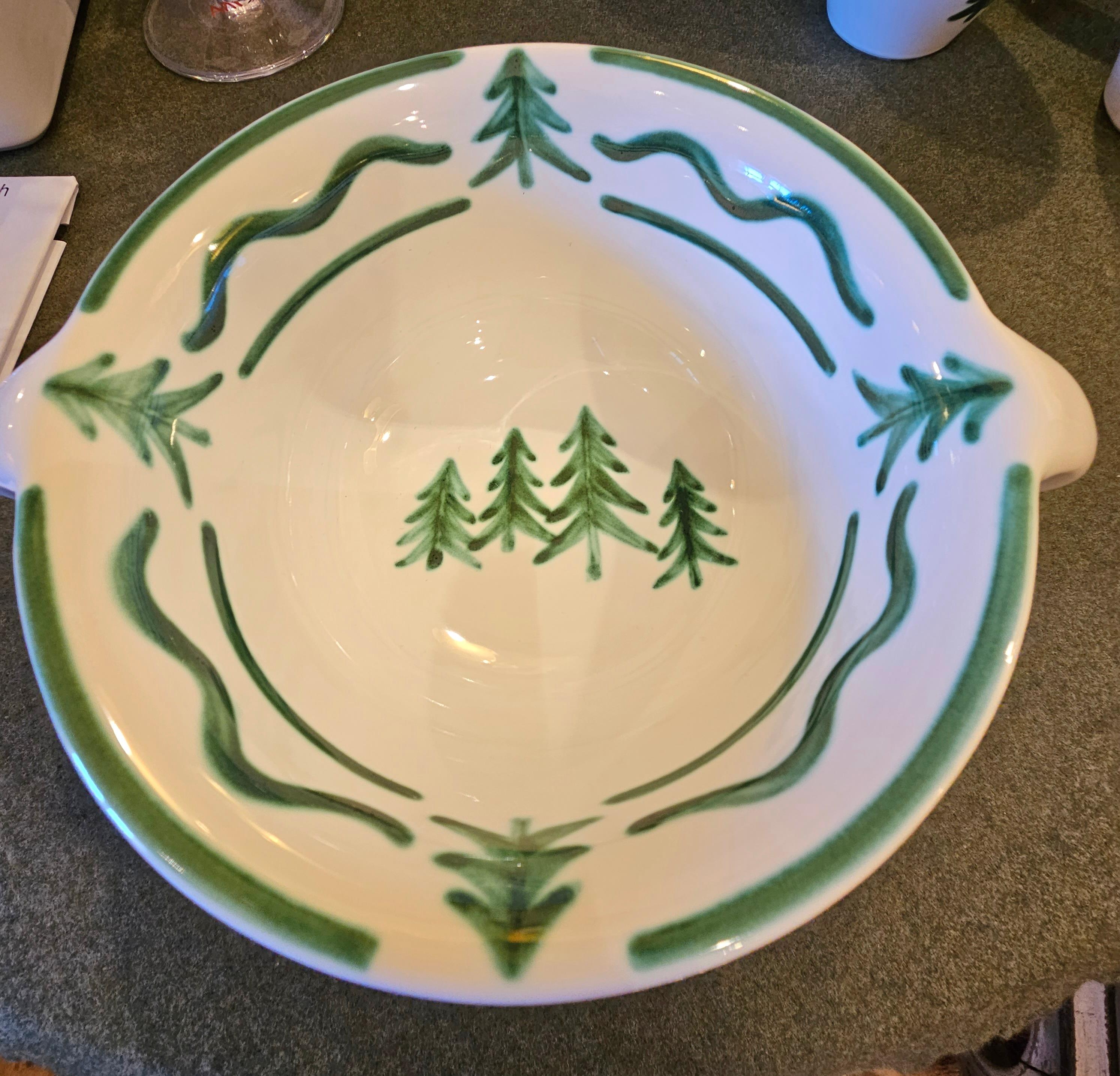 Hands-free painted round pottery dish from Austria in Black Forest style. Decorated with a hand-painted tree decor in green all around. Showing trees in the bottom and a handpainted green garland around. Produced in Austria in the typical Austrian
