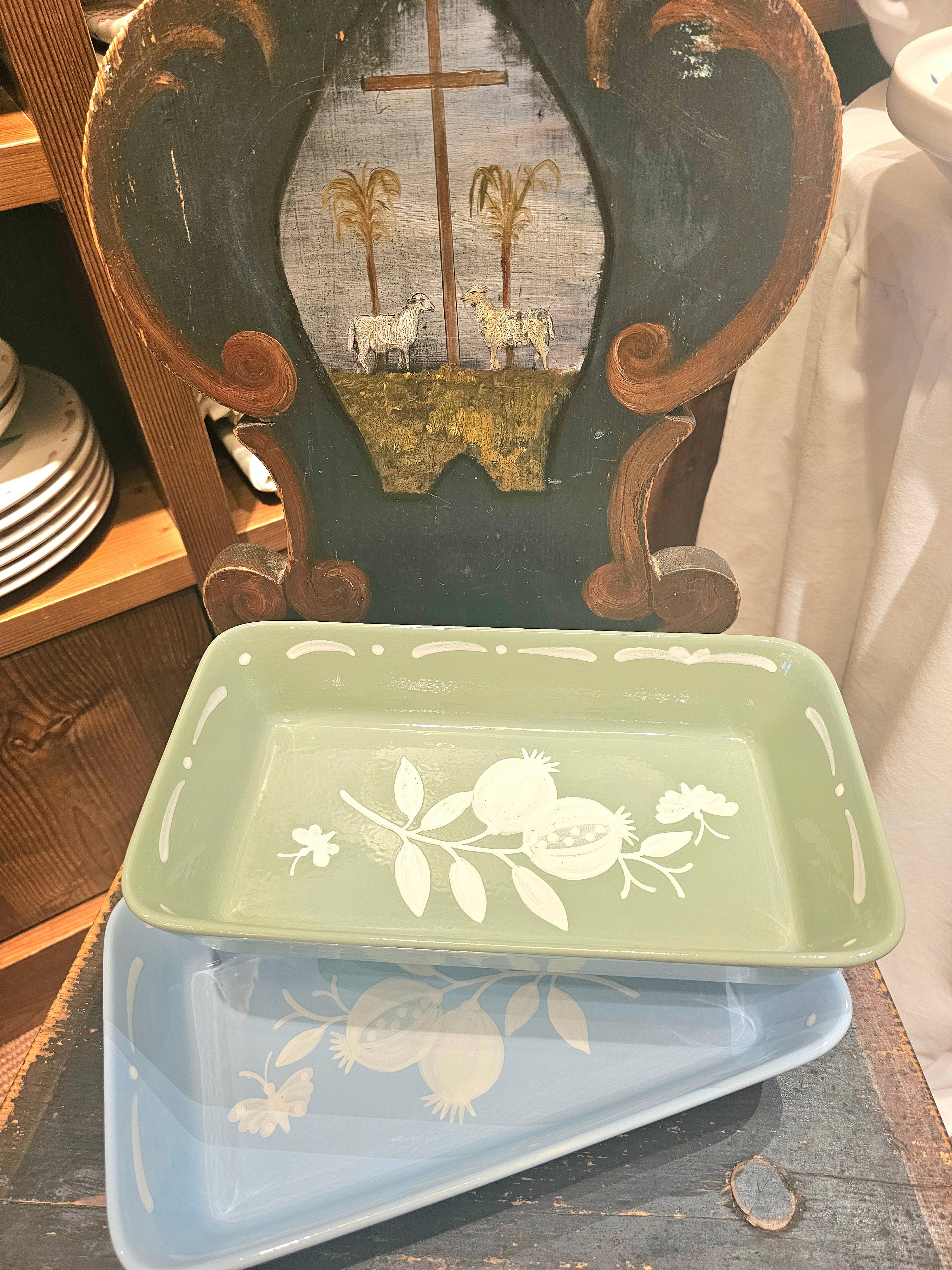 Piatto rettangolare in ceramica dipinta a mano libera di colore blu proveniente dall'Austria in stile country. Decorato con un melograno dipinto a mano libera e una ghirlanda bianca tutt'intorno. Mostra degli alberi nella parte inferiore e una