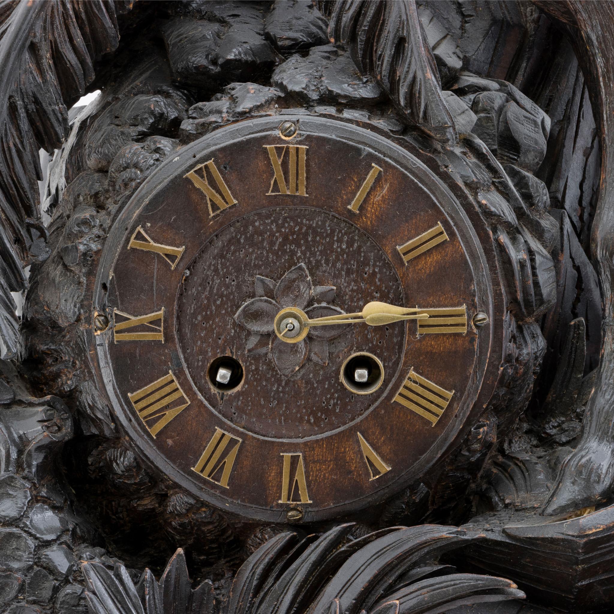 Horloge de manteau sculptée en Forêt Noire avec fleuron en forme de cerf rouge. Le mouvement de l'horloge est marqué 