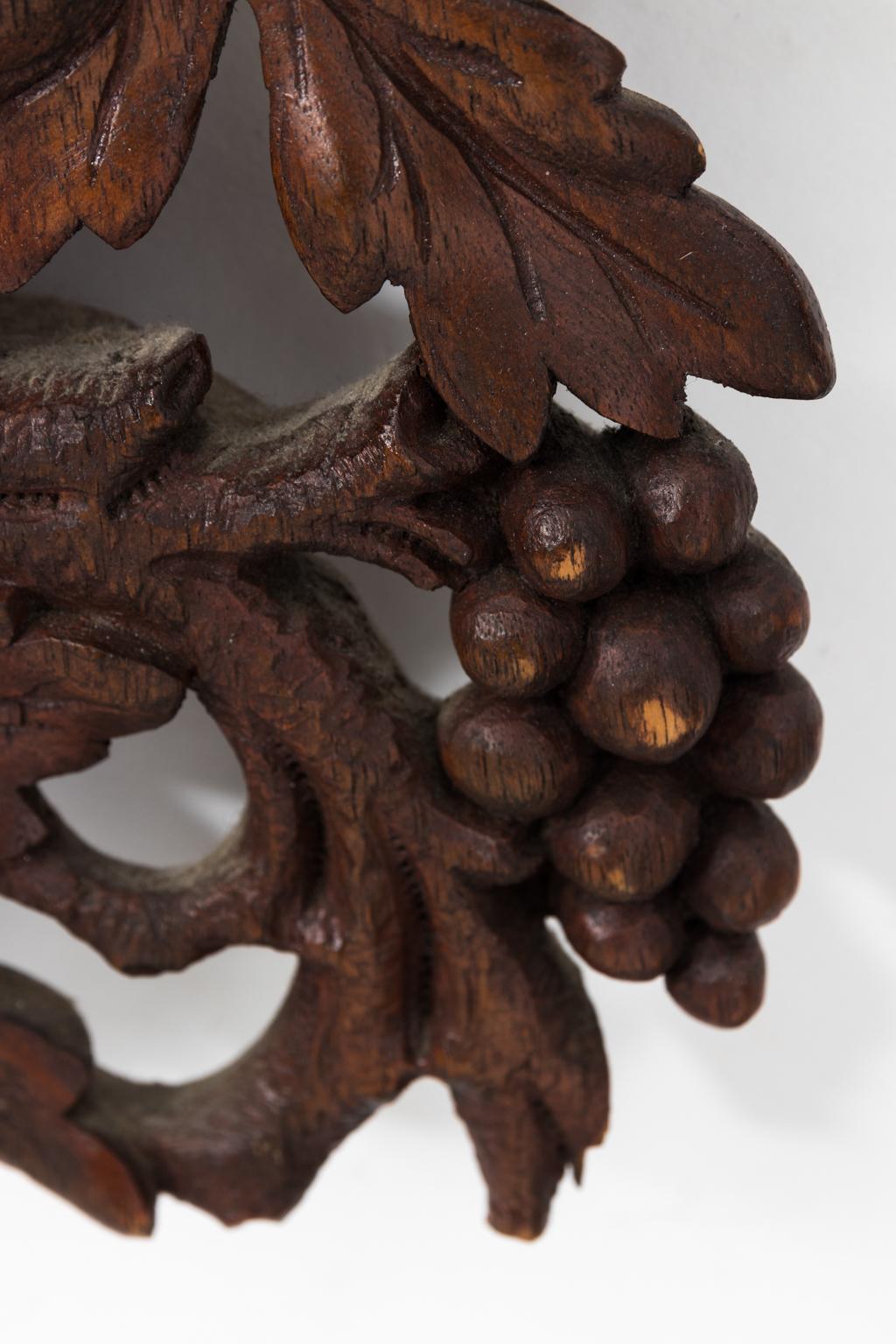 Carved Black Forest mirror with tree branches and berries, circa 20th century.
 