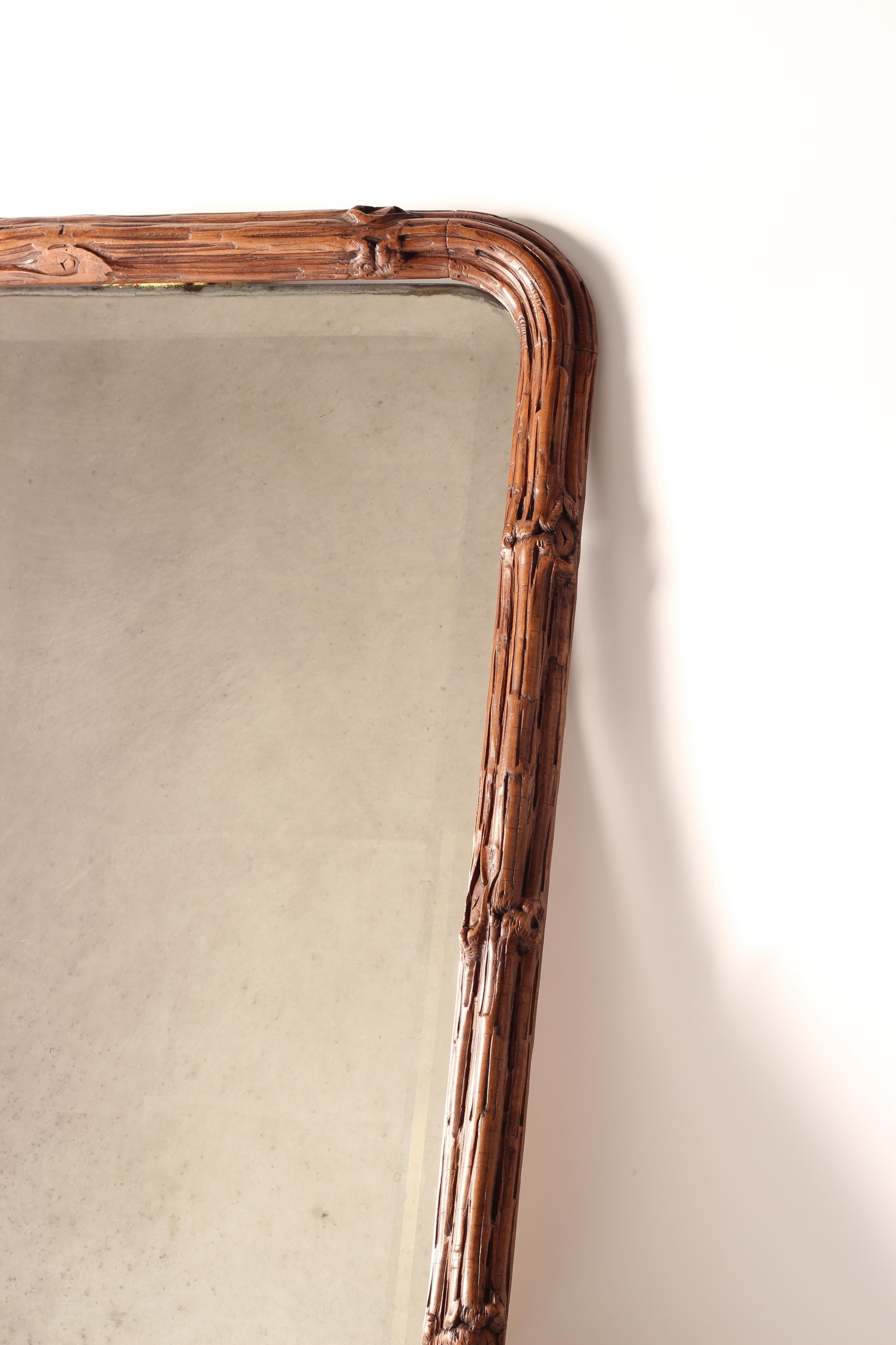 Il s'agit d'une paire de magnifiques miroirs incroyablement bien sculptés, qui reproduisent une bordure de branches s'enroulant autour d'un miroir original biseauté et incurvé. La sculpture est en très bon état d'origine, le miroir ne présentant