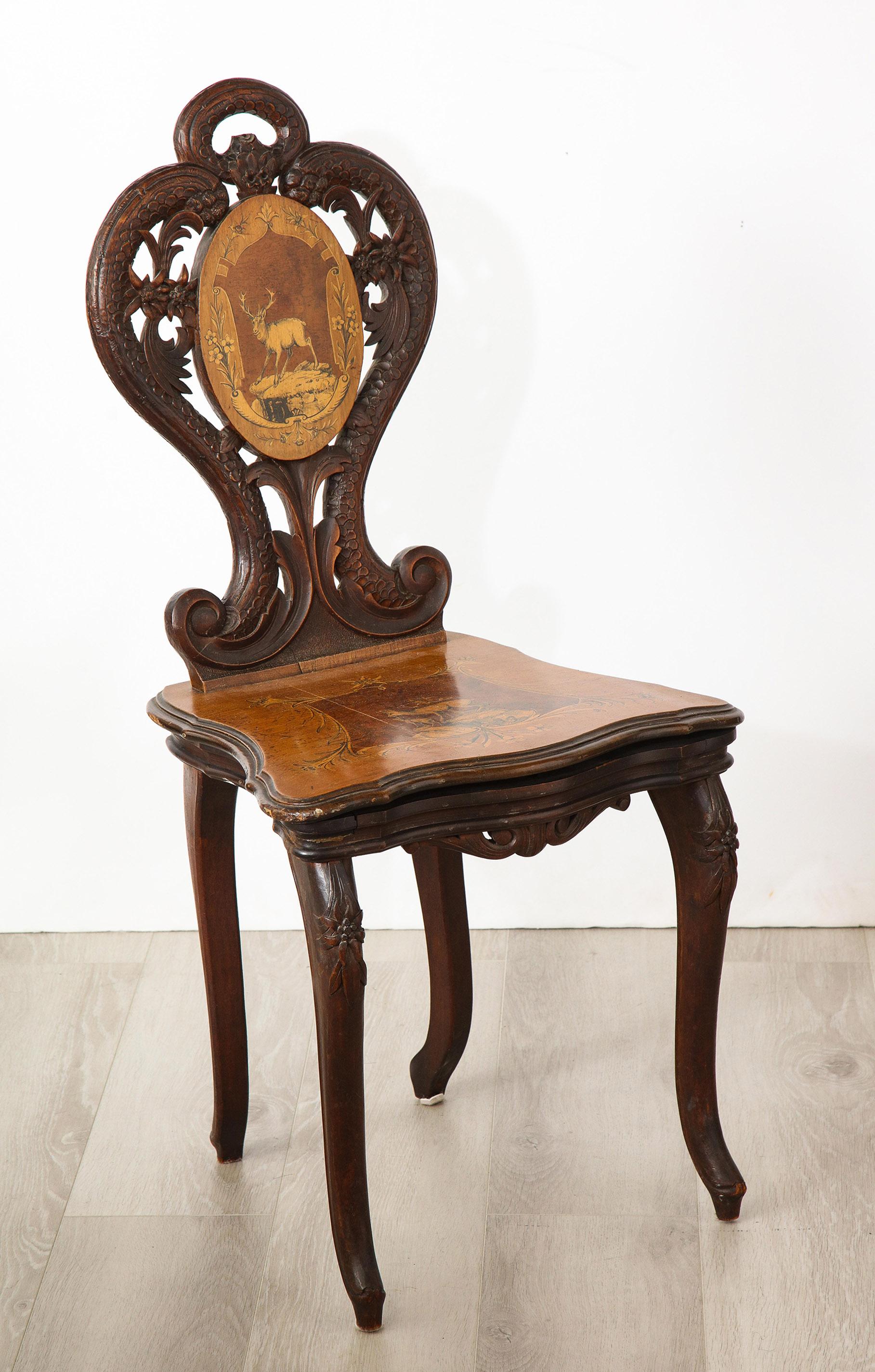 The all over carved chair with a marquetry inlaid back and seat presenting superb examples of original pen-work. The seat opening to reveal an original music box.
  