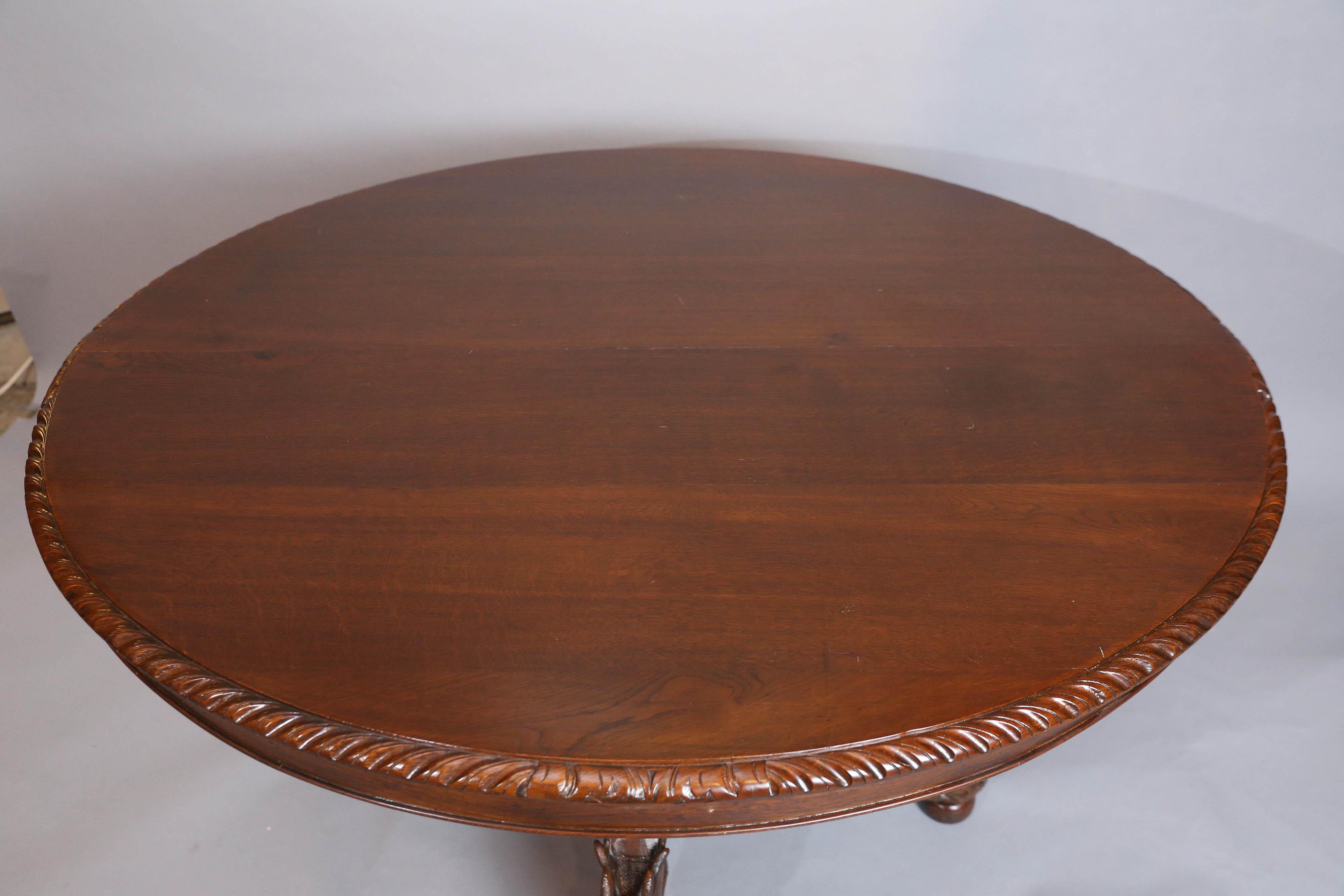 Black Forest oak oval centre table features gadroon carving around circumference of top and rests upon an elaborately carved base,
The four legs that extend from the balustrade pedestal are carved with various animals, including, a fox, a hound, a