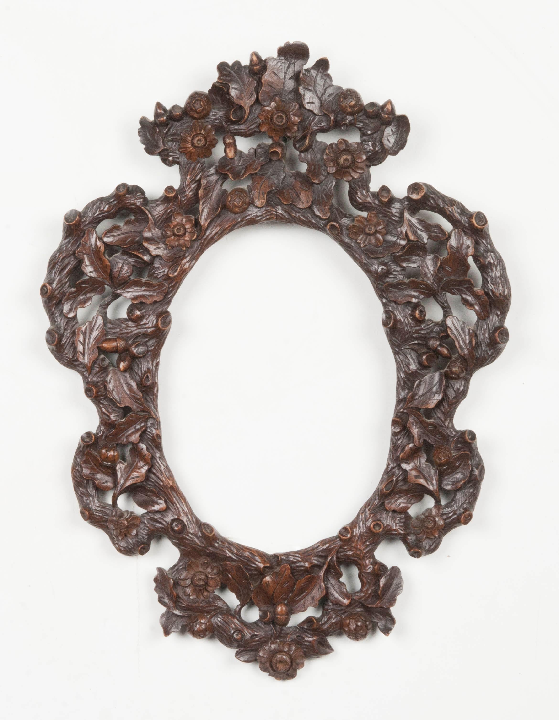 Rich and refined wood-carved photo frame. A typical example of the Black Forest style, decorated with leaves, branches and acorns.
The frame has a beautiful patina.