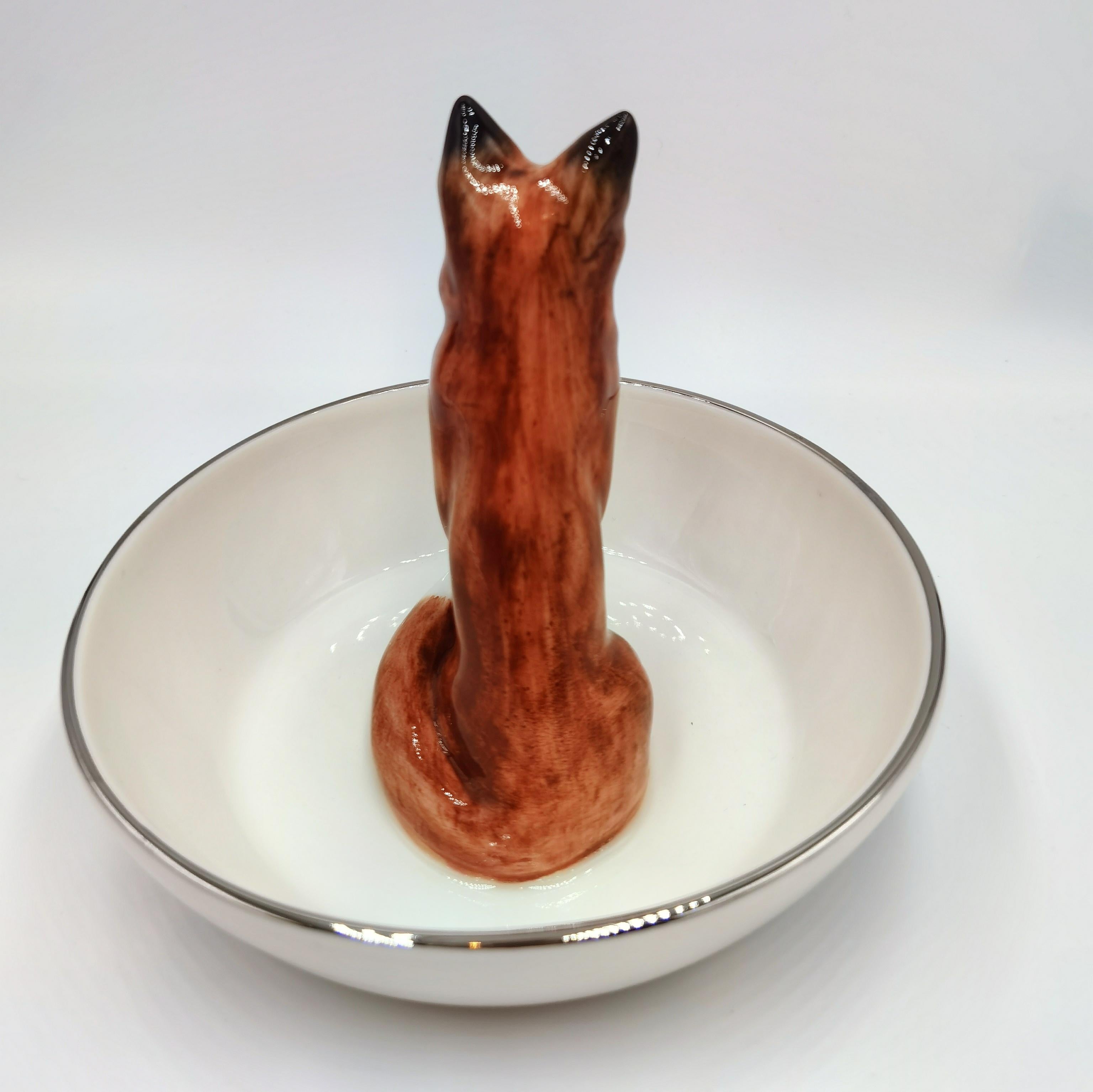 Completely handmade porcelain bowl with a hands-free natrualistic painted fox figure in brown colors. The fox is sitting in the middle of the bowl for decorating nuts or sweets around for a grerat black forest interior style. Rimmed with a fine