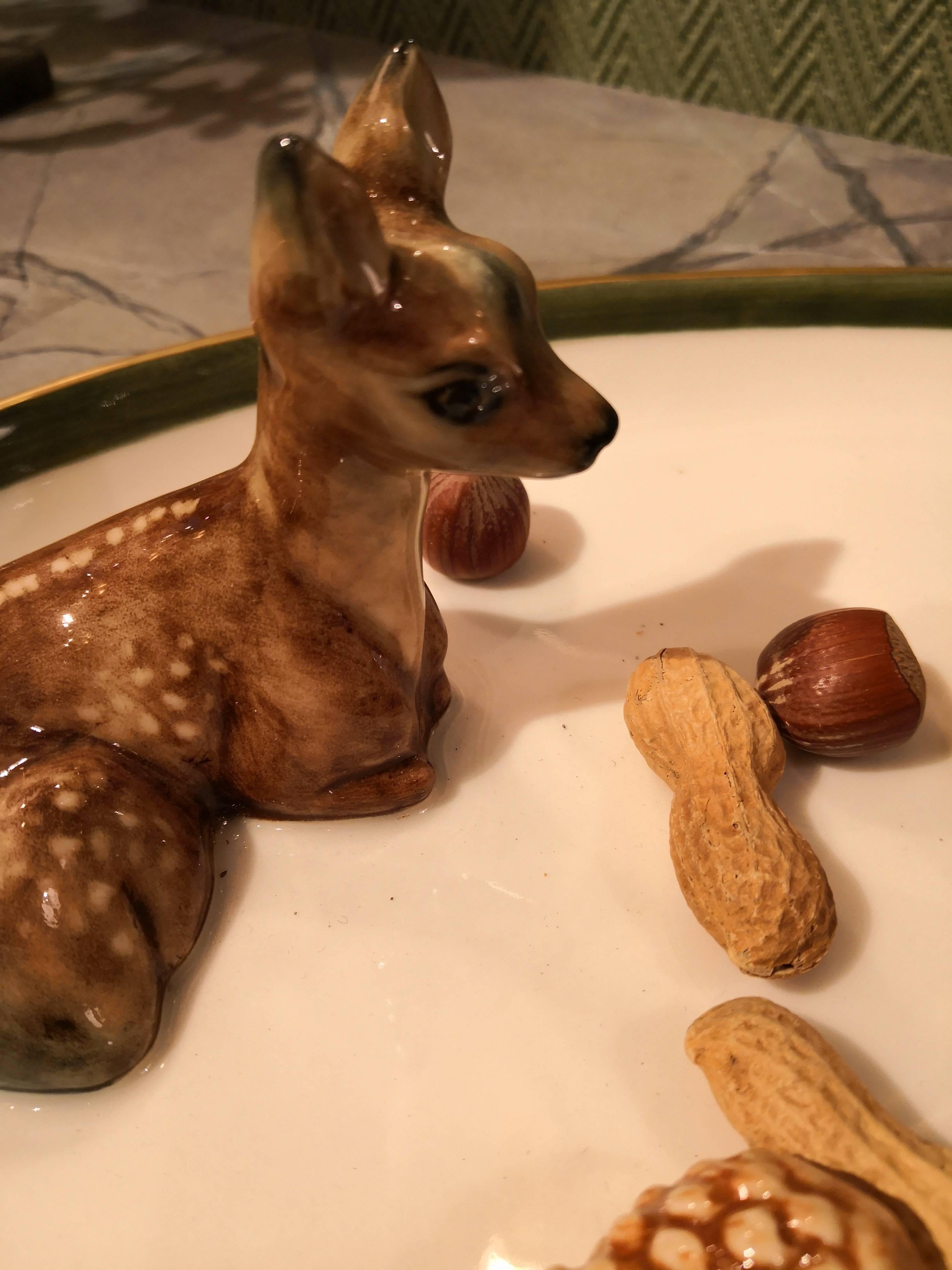 Charming completely handmade and hands-free painted oval porcelain plate. The naturalistic moulded porcelain bambi figure and three porcelain pine cones fixed on the porcelain plate are hand-painted and decorate your home in a warm atmosphere. One