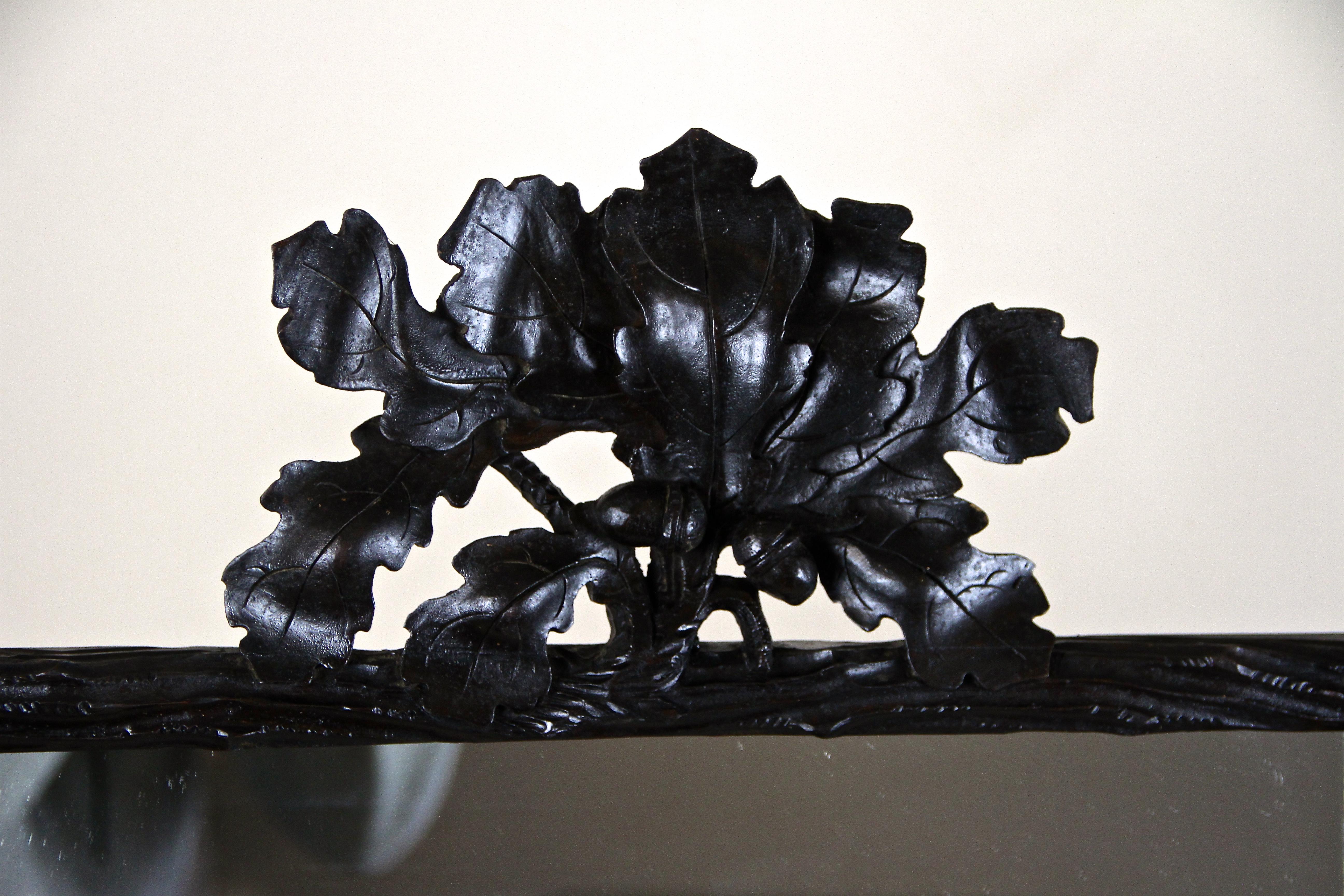 Intagliato a mano Specchio rustico Black Forest con intagli di foglie di Oak e ghiande, Austria, circa 1870 in vendita
