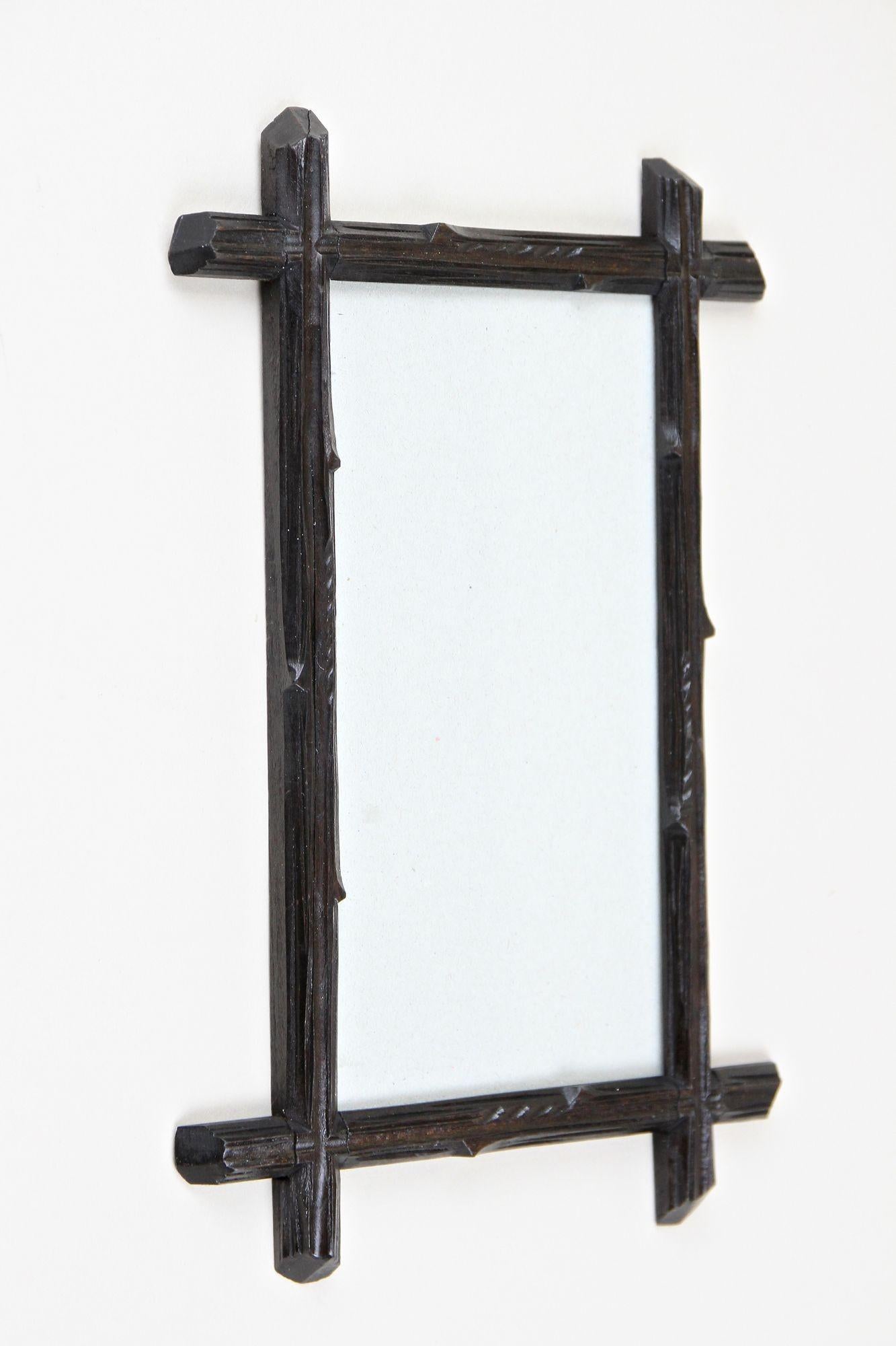 Lovely rustic black Forest photo frame from the late 19th century, around 1880 in Austria. Elaborately hand carved out of bass wood this antique photo frame shows a charming traditional tree trunk design which the dark brown almost black stained