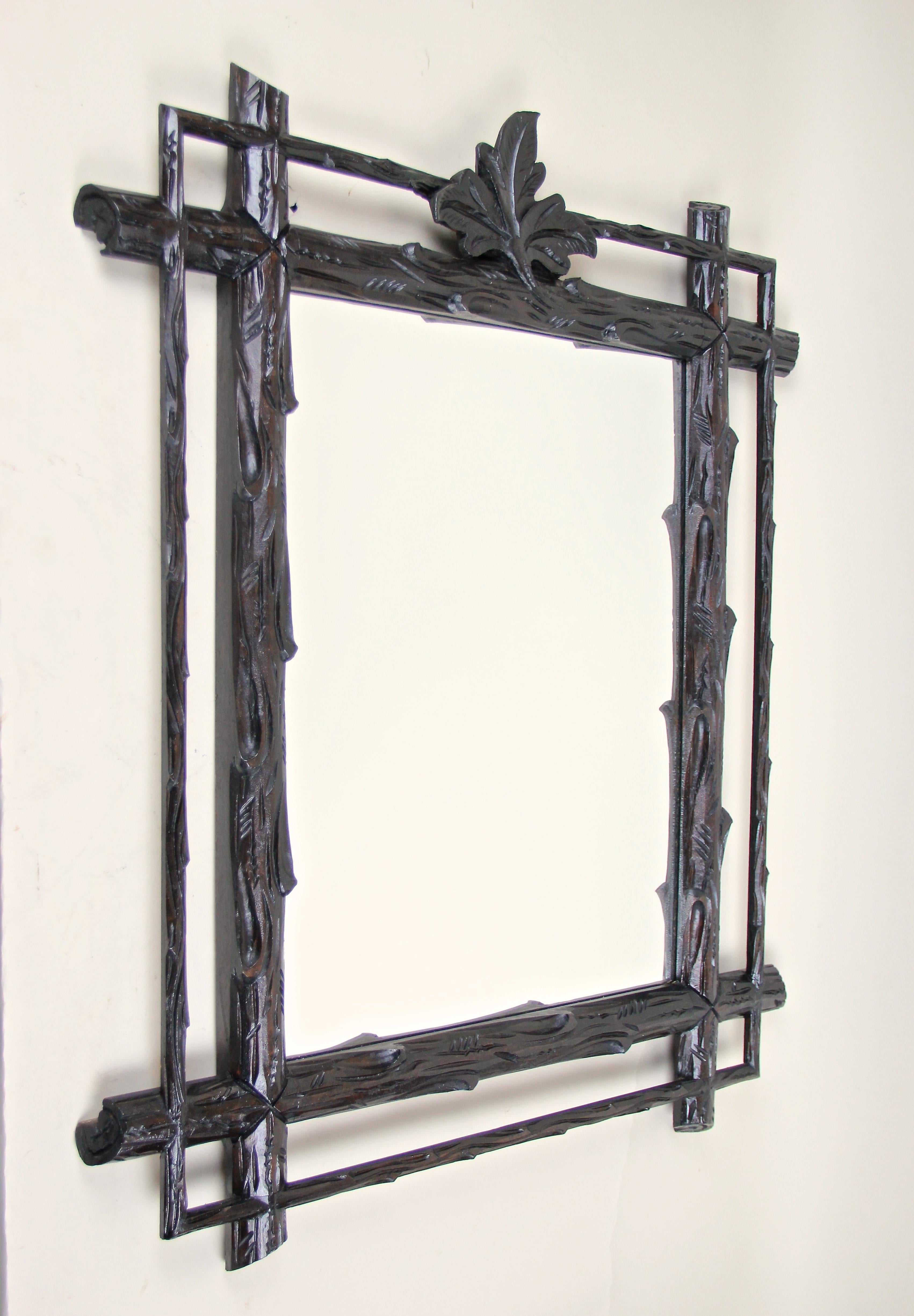 Mesmerizing rustic Black Forest wall mirror from the late 19th century out of Austria. Handcrafted out of fine basswood, this charming mirror shows an extrordinary rural design: a doubled frame in the manner of tree branches with protruding corners